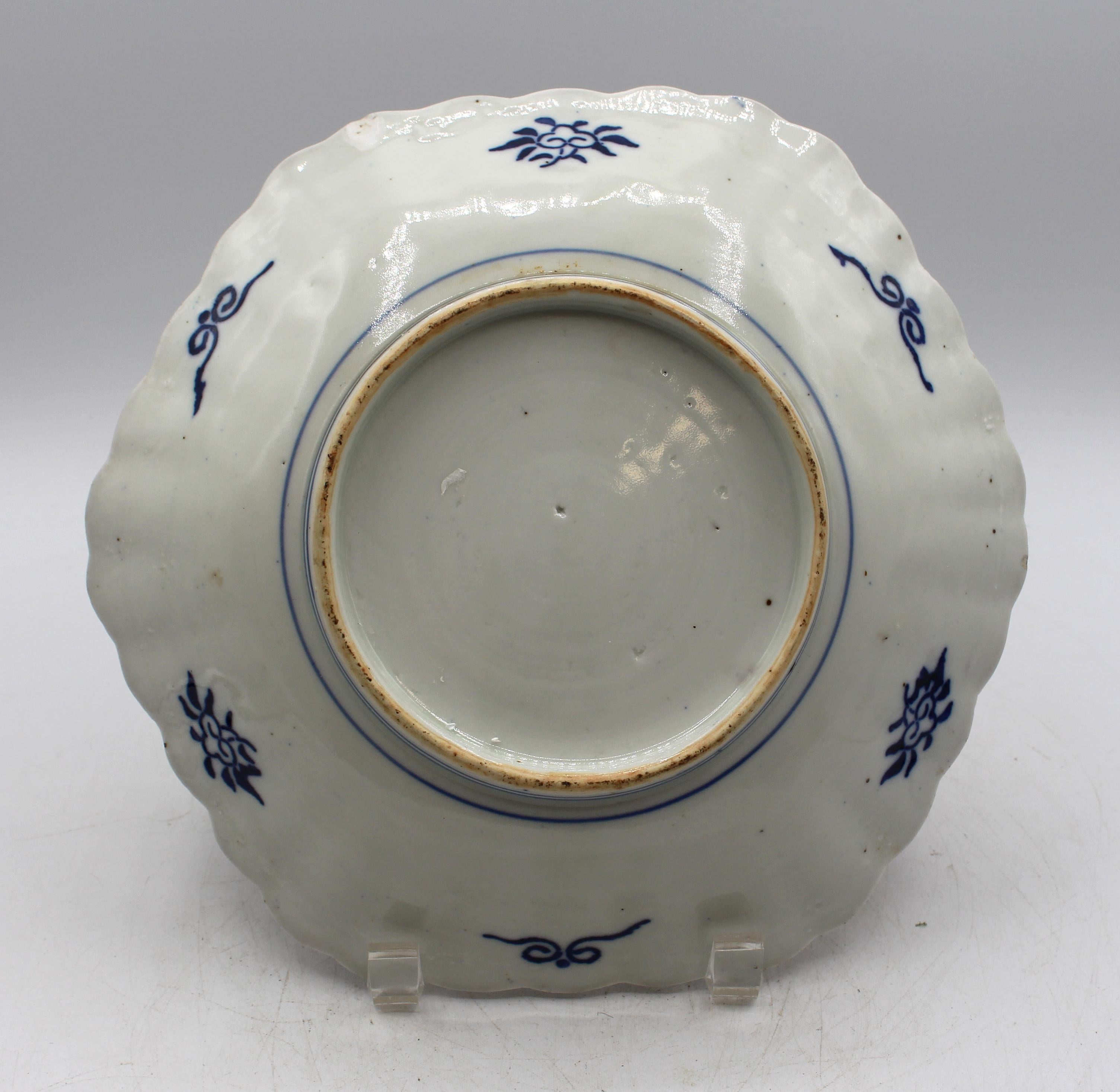 Circa 1880 scalloped Imari plate, Japanese. Hexagonal shape. Floral urn on stand central reserve. Well scalloped; cartouches with floral decoration. Underside chip.
9 5/8