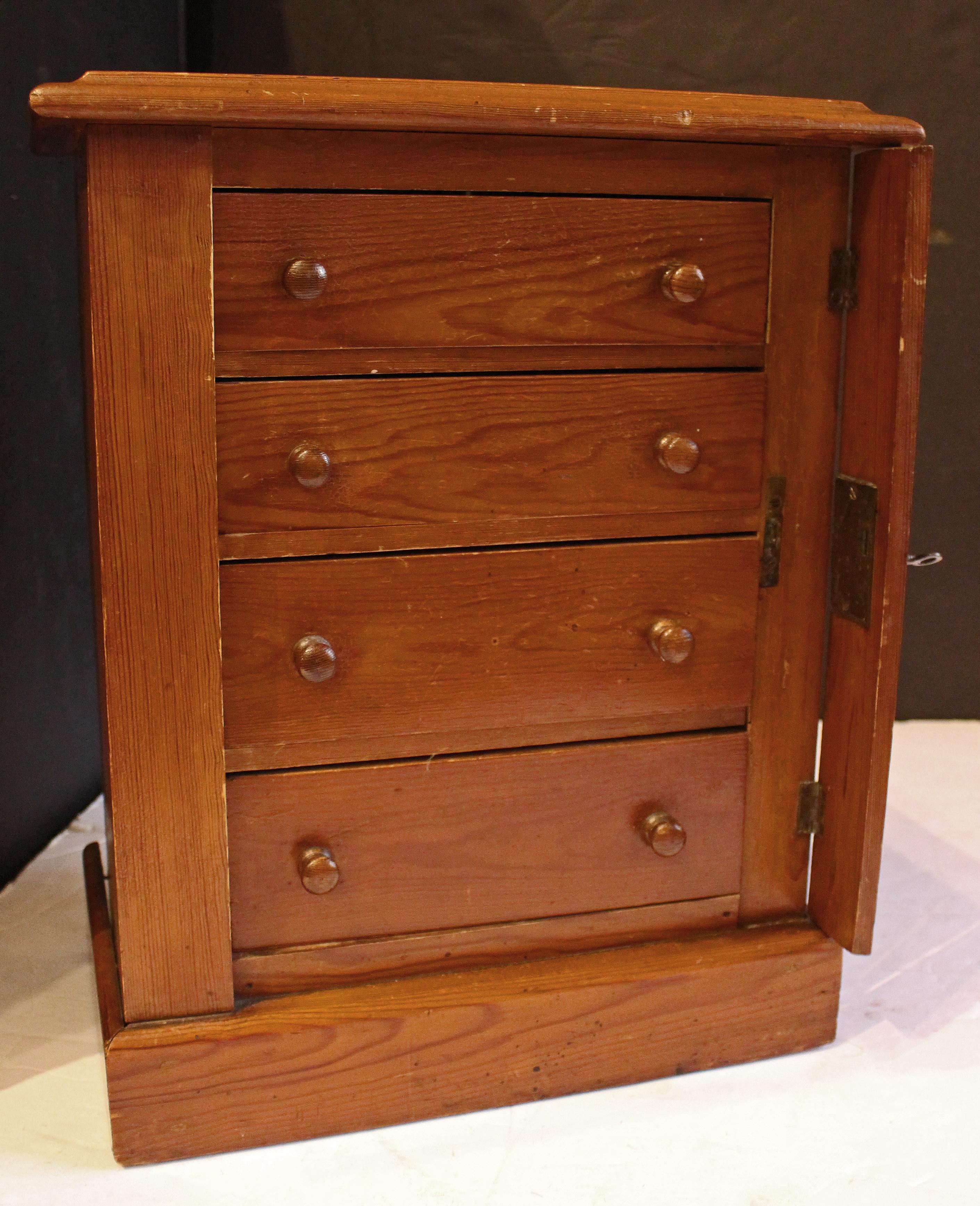 Cassettiera Wellington in miniatura o per bambini, 1880 circa, inglese. Pino silvestre. Serratura laterale e chiave originali. Semplice costruzione con chiodi per un bambino che gioca. Piano e base a zoccolo ben modellati. Pomelli in legno