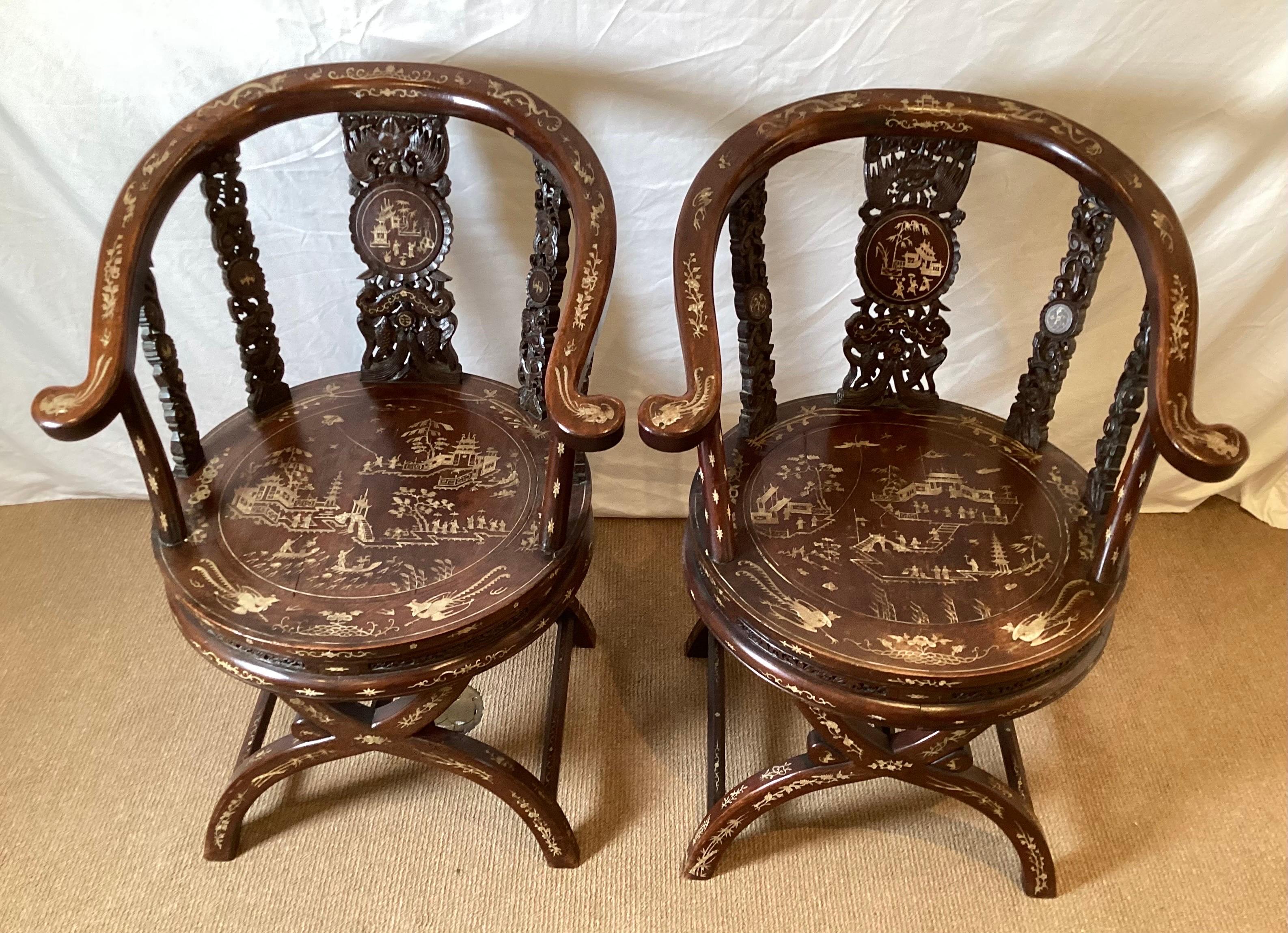 Intricately carved Chinese hardwood horseshoe back armchairs with detailed inlay of bone. The inlay depicts townspeople and architectural elements along with winged birds with other inlays of floral groupings.