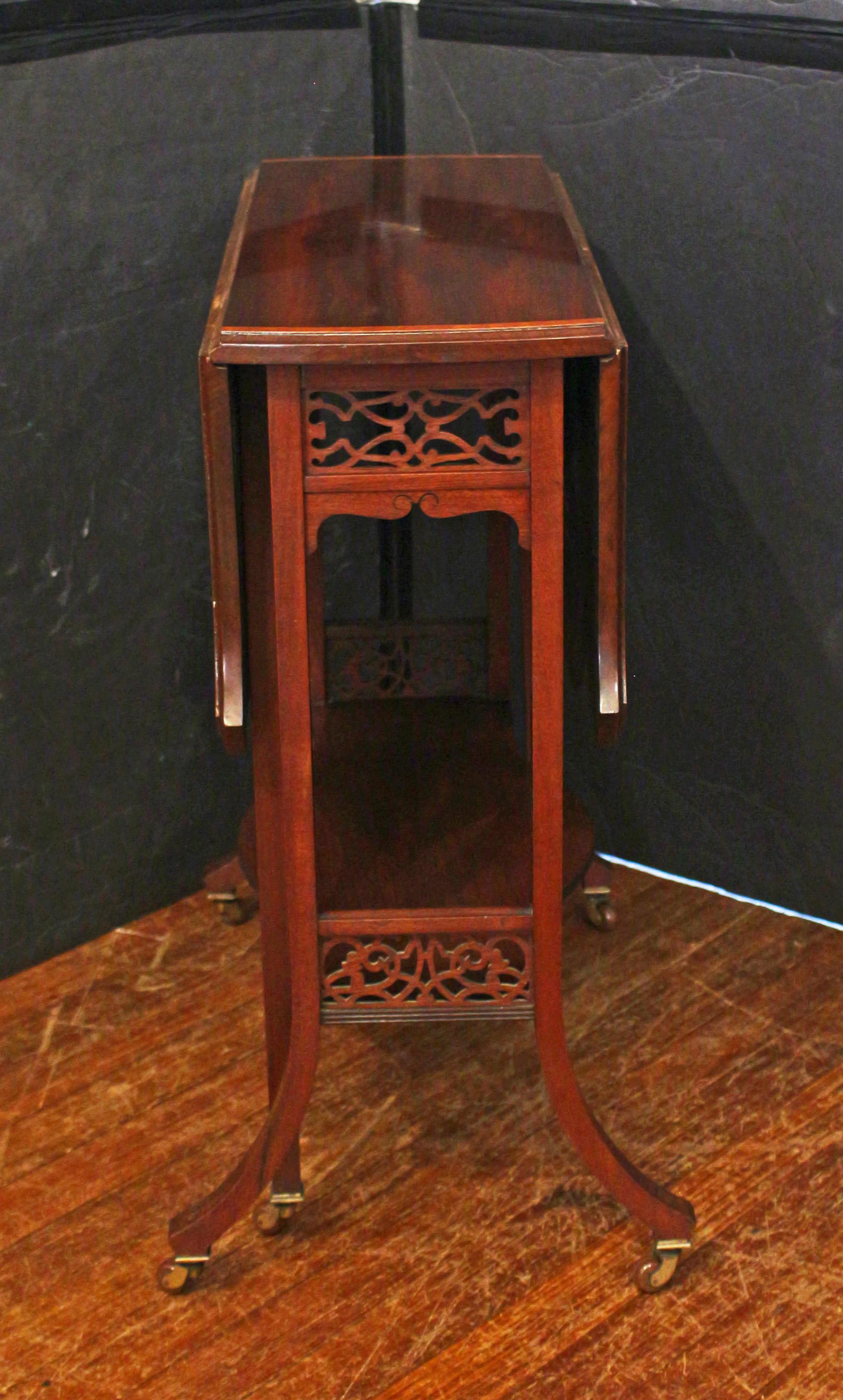 Circa 1890 Sutherland Table with fretwork side panels, English. Mahogany with satinwood banded & line inlaid top. Elegantly splayed legs with caster feet. The turtle shell or double serpentine shaped top adds great visual interest open or closed.