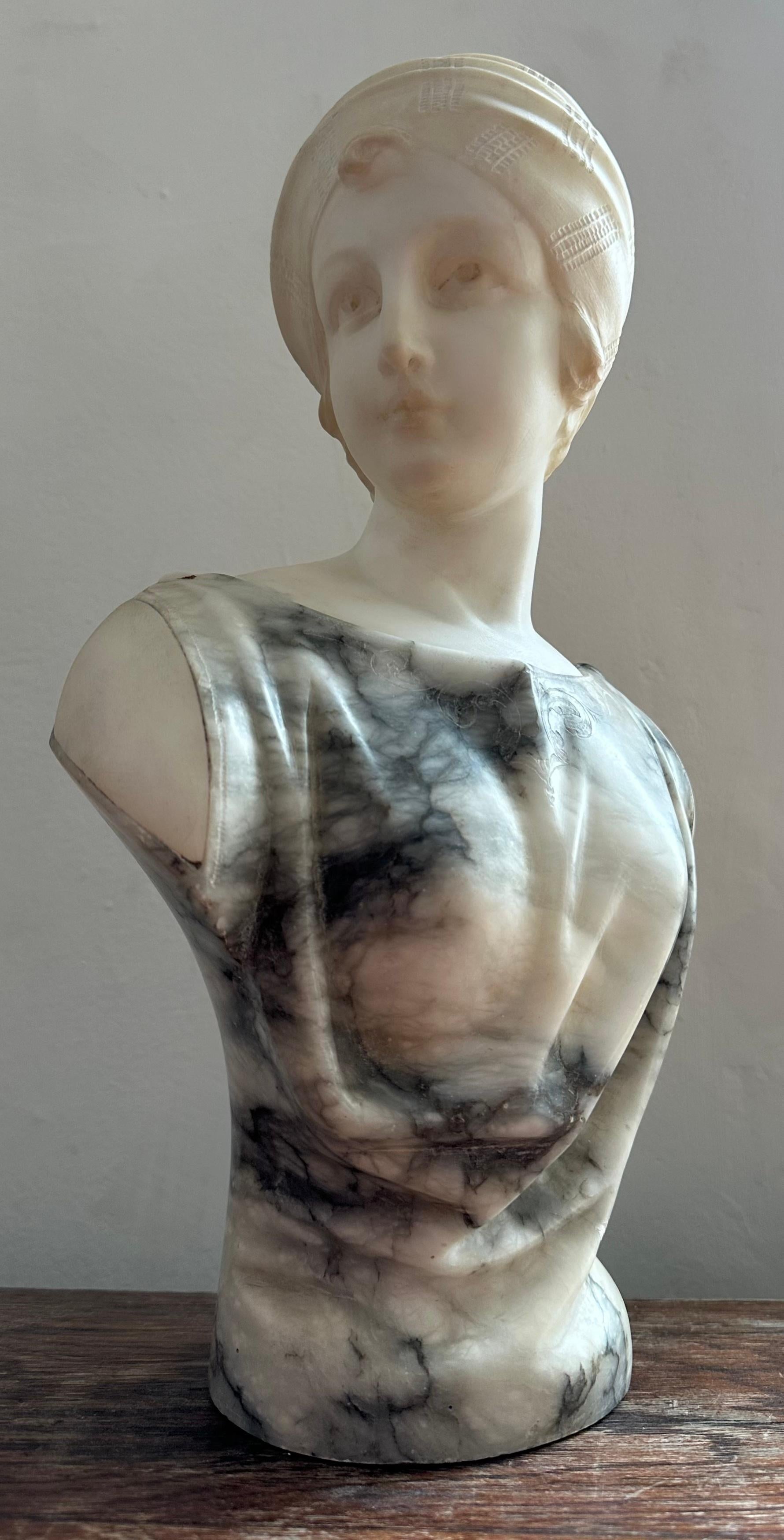 Circa. 1890 Buste en marbre italien d'une élégante dame par Guglielmo Pugi.  Buste en marbre magnifiquement sculpté, représentant une femme portant un turban ou une coiffe minutieusement sculptée, regardant vers sa droite. La dame porte une robe