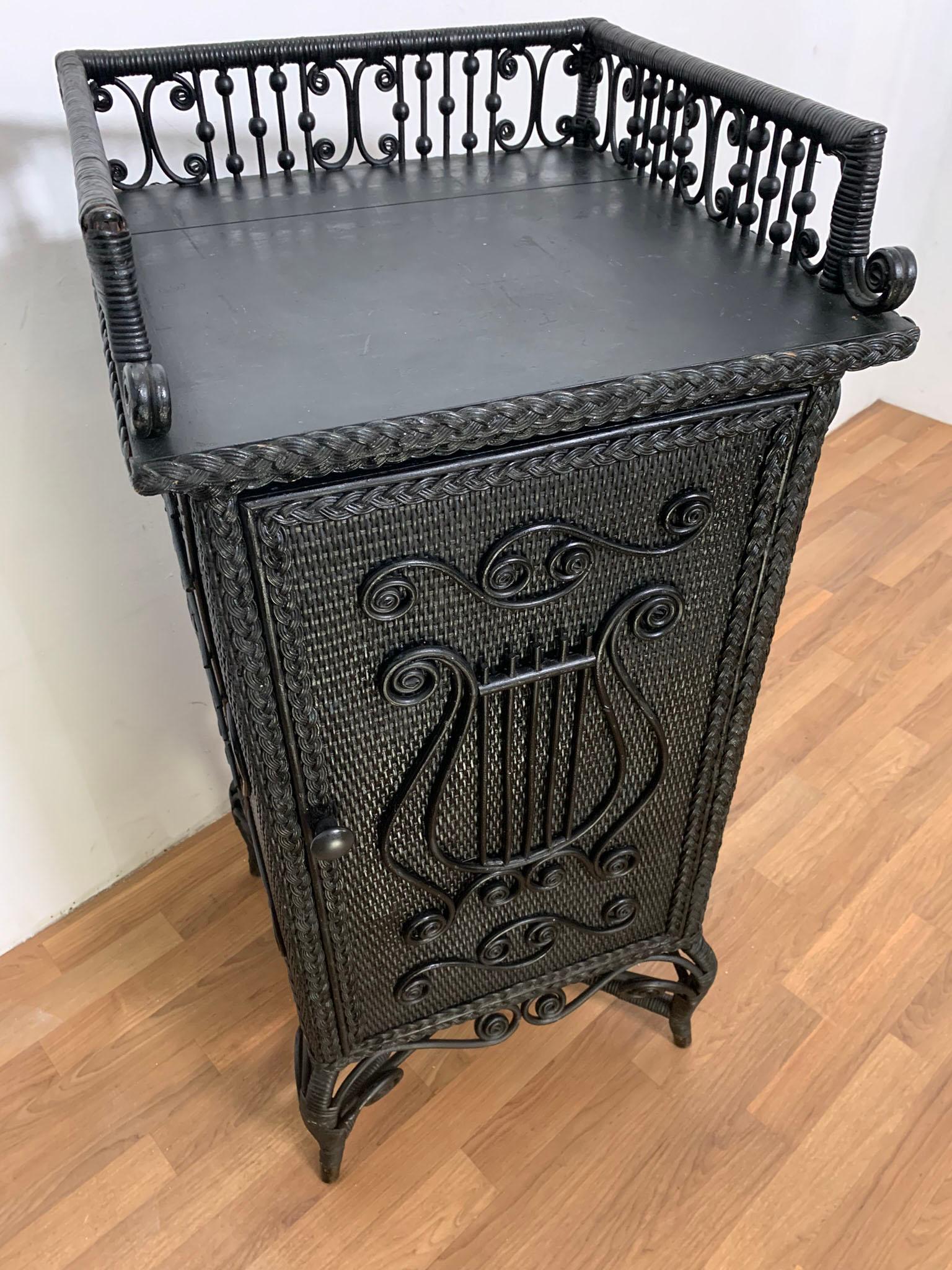A rare Aesthetic Movement music cabinet adorned with musical notes, in original ebony finish by the Heywood Brothers and Wakefield Company, circa 1890s.