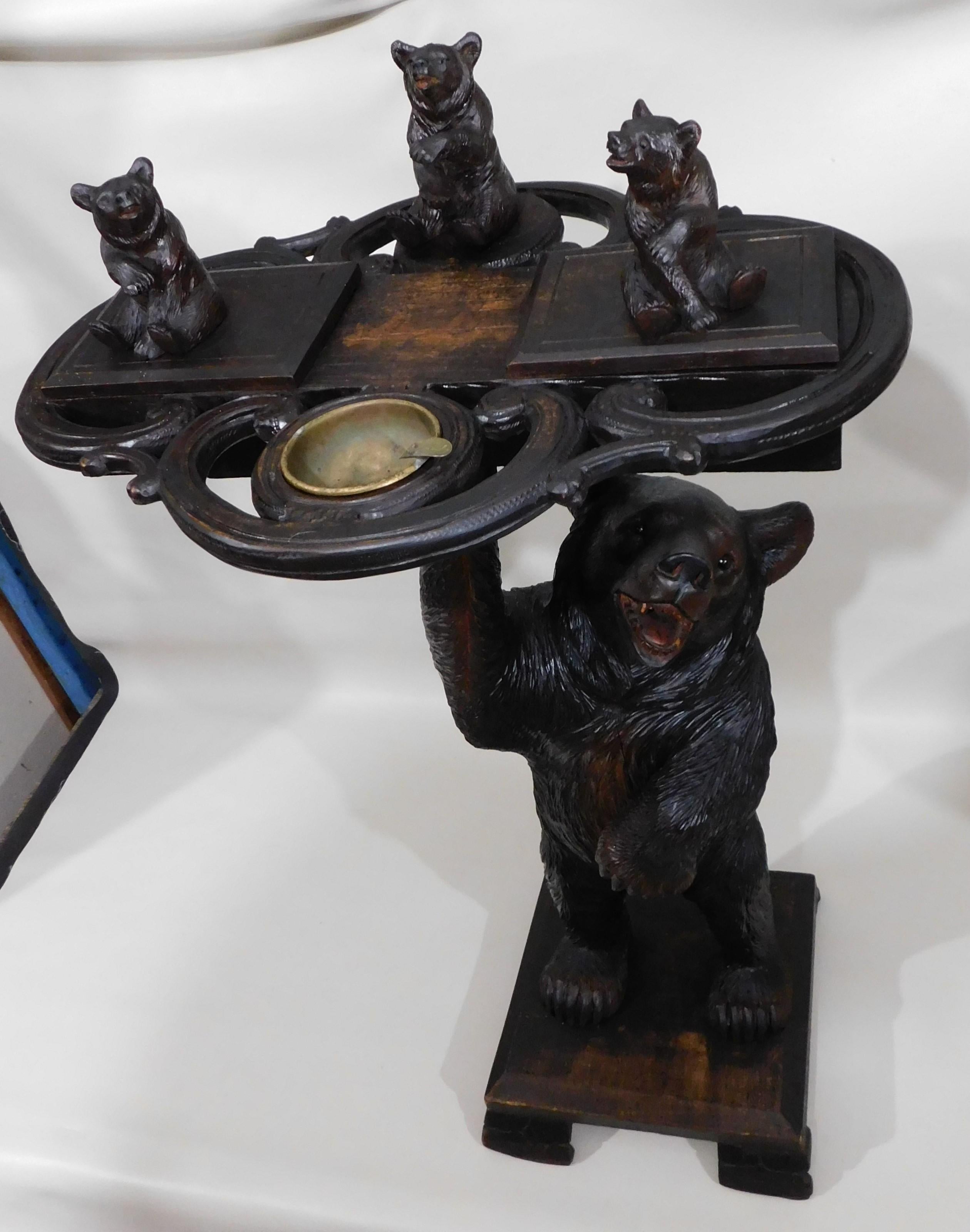 Very stylish Black Forest wood smokers stand, circa 1890. The stand is topped with three realistically carved bears and has a brass ashtray. The two bears at the front are hinged and open to reveal small compartments. The top is being held up by a