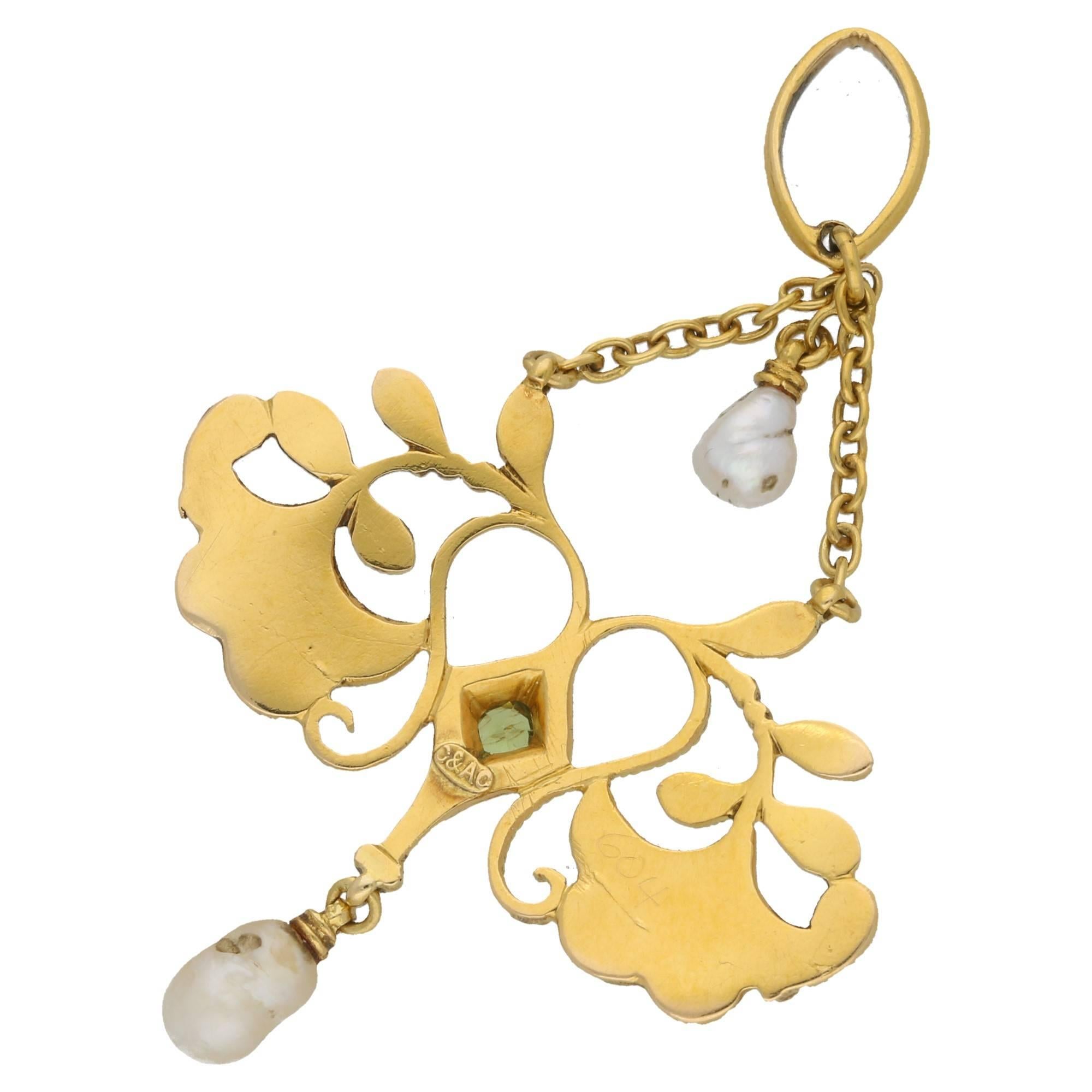 An elegant Art Nouveau Carlo Giuliano enamel, pearl and demantoid garnet pendant set in 18 carat yellow gold. The pendant is set with two unique natural pearl drops above and below the panel set green garnet. On either side we see hand enamelled