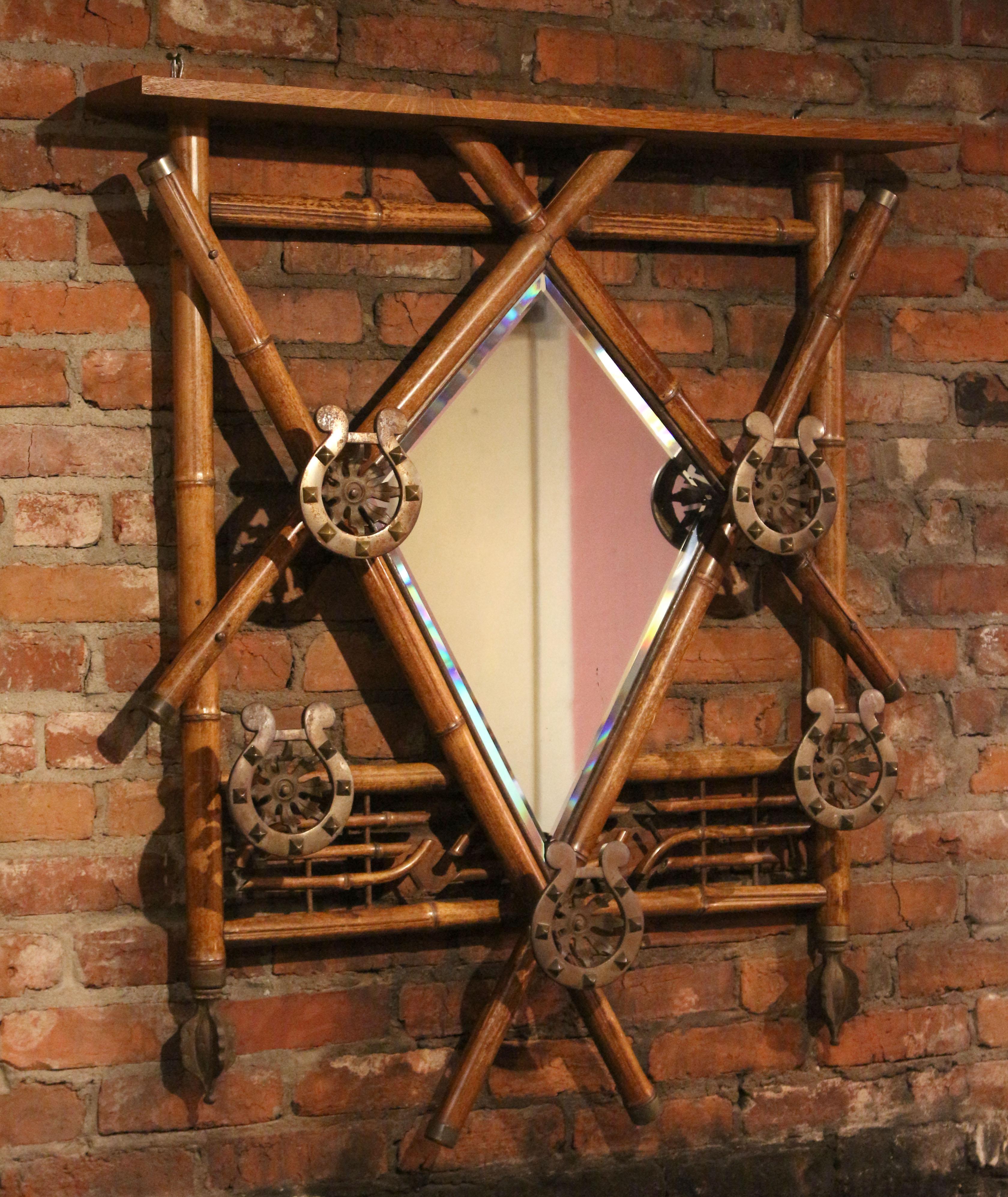 English Bamboo Hanging Hall Rack with Mirror, circa 1890s. Five bold horseshoe motif coat or hat hooks. Bevelled mirror plate. Oak top shelf. Decorative metal finial drops & brass caps. Bamboo lattice decoration.
37 3/8