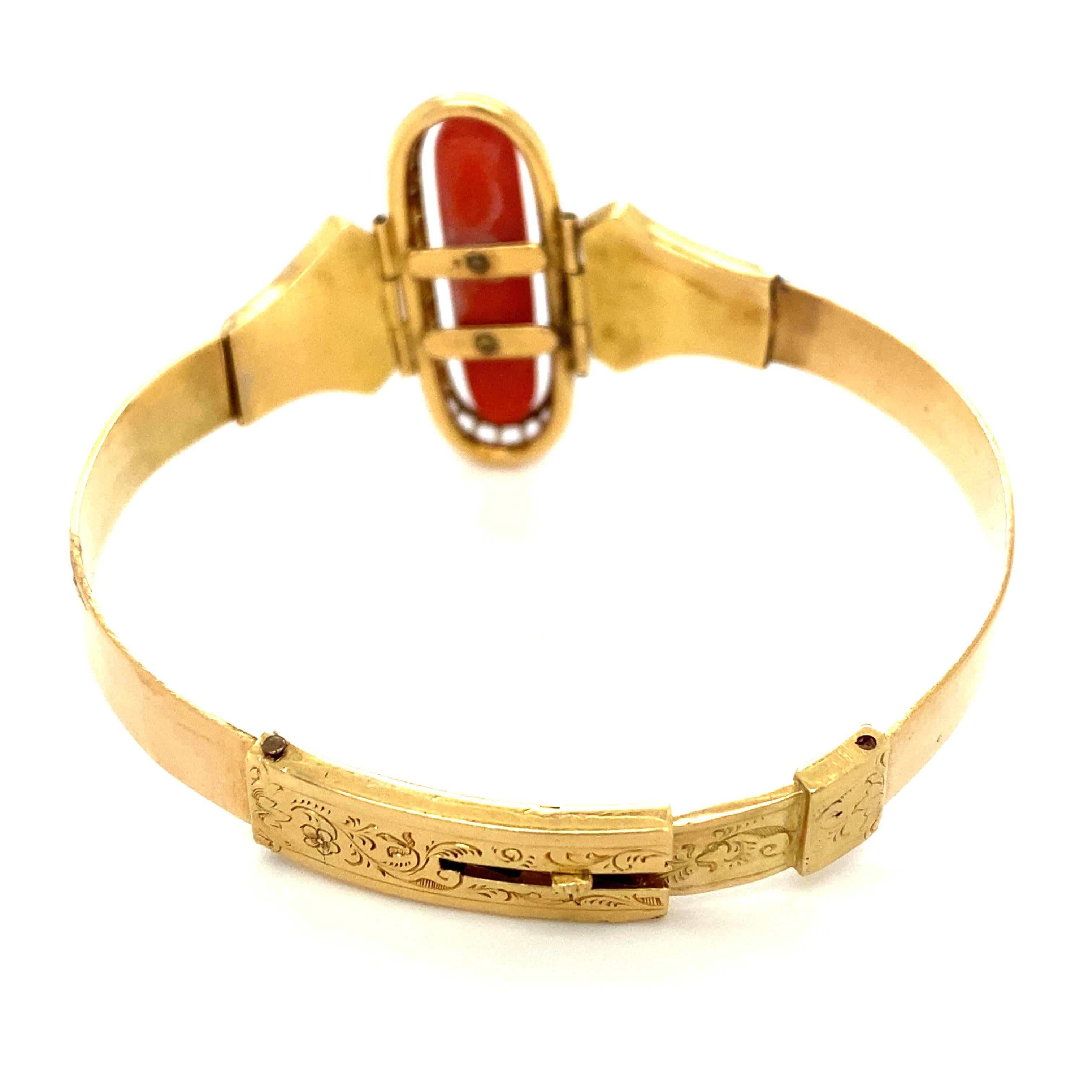 Item Details: This beautiful bracelet dates from the Victorian Period and features a large deep orange coral with diamond inlay. It has goldwork detailing on the sides and on the clasp. It has hinged around the center piece and is slightly flexible,