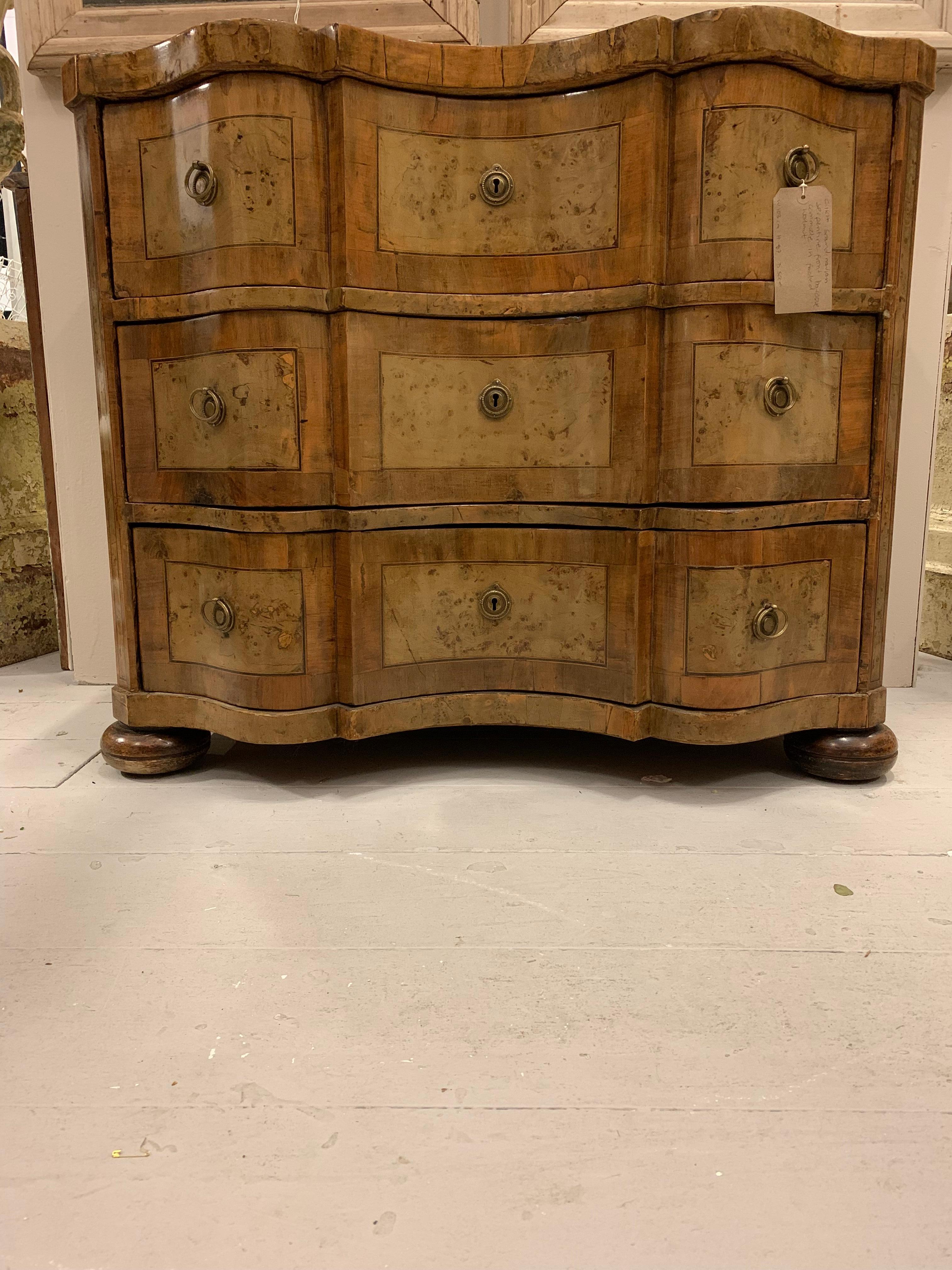 Wonderful late 18th century Swedish baroque commode.
The decorative serpentine front is in two tones of muted and pale walnut.
It has three deep useful drawers with the original hardware and sits on bun feet.
A versatile statement piece that