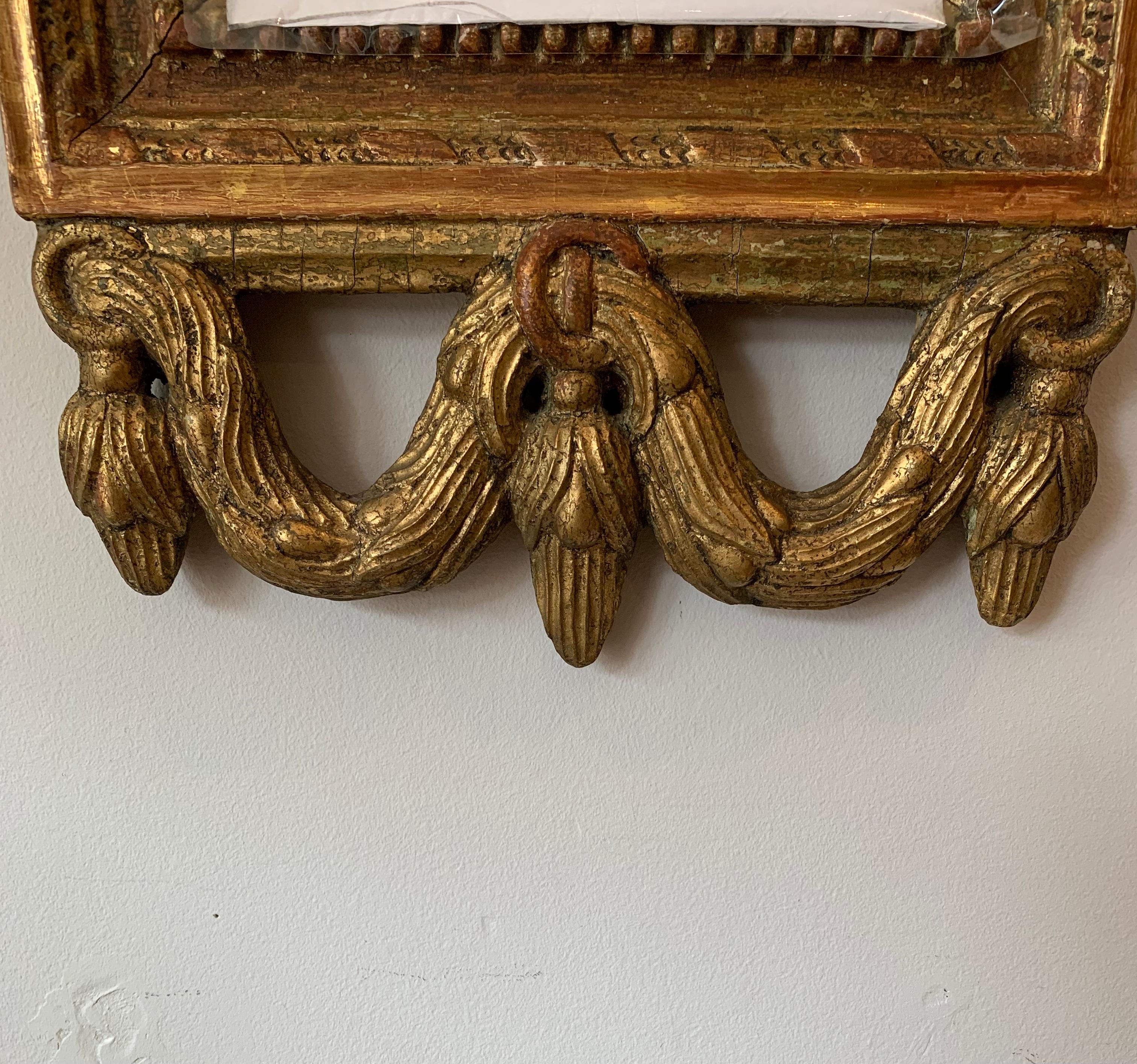 Carved Circa 18th century Swedish gilt mirror with urn & swag decoration