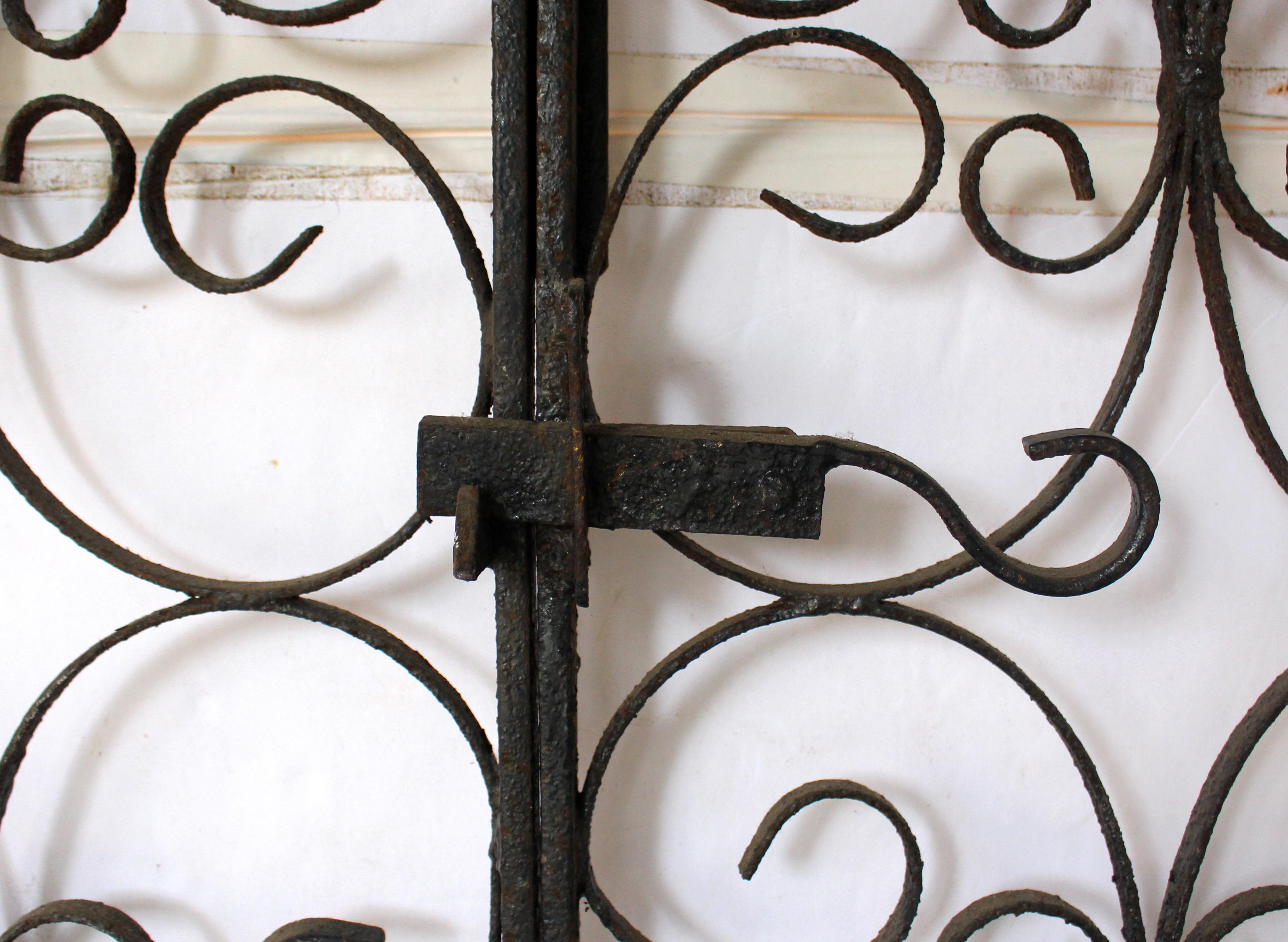 Circa 1900-1925 Pareja de puertas inglesas de hierro forjado para jardín o entrada de vehículos. Con pestillo accionable y monturas. El diseño barroco claro presenta múltiples motivos de volutas S y C. Buen estado de conservación. 87 7/8