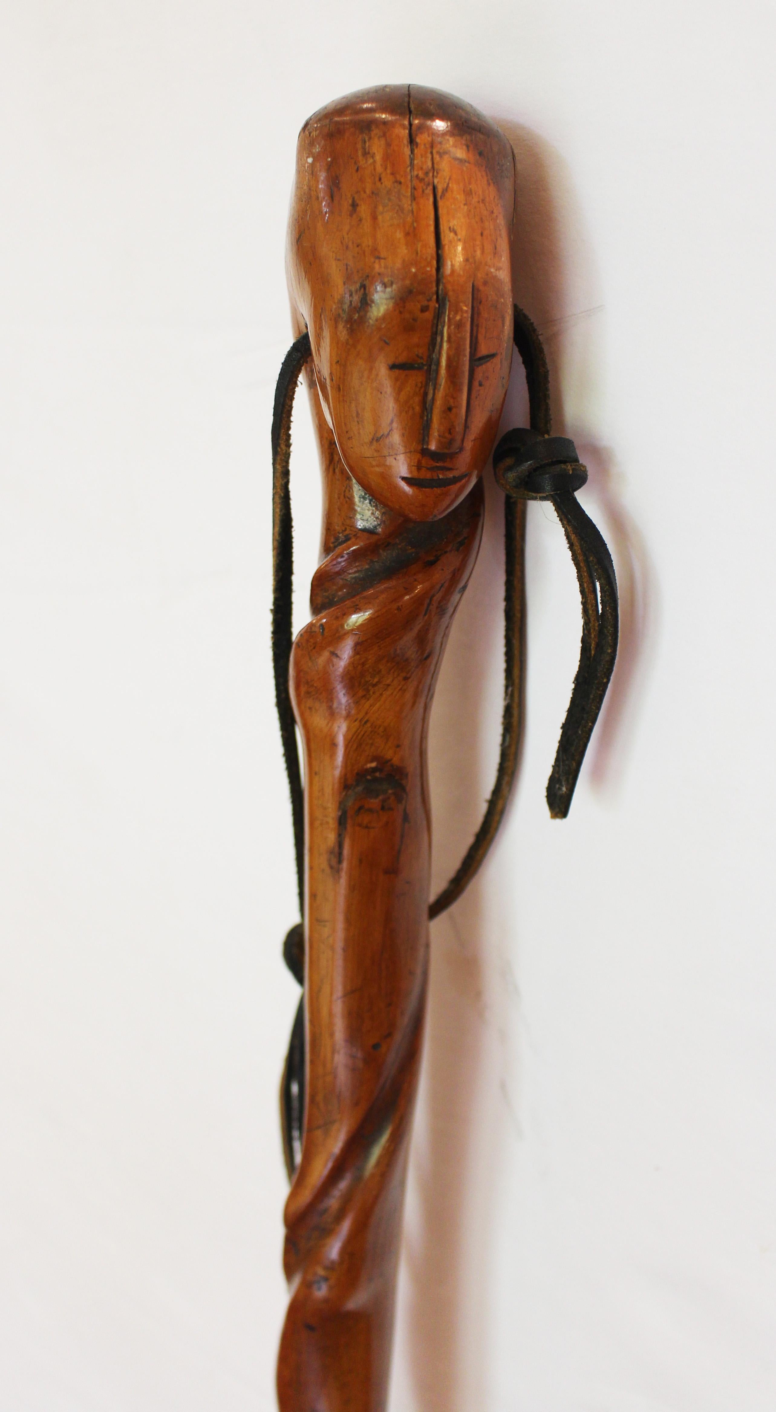 Circa 1900 antique African walking stick. Dense hardwood. Crack at one twist - natural from aging. Colonial era with brass tip, likely Shona people of Zimbabwe. The elegantly handsome abstract face is truly splendid. Fissures run through top of head