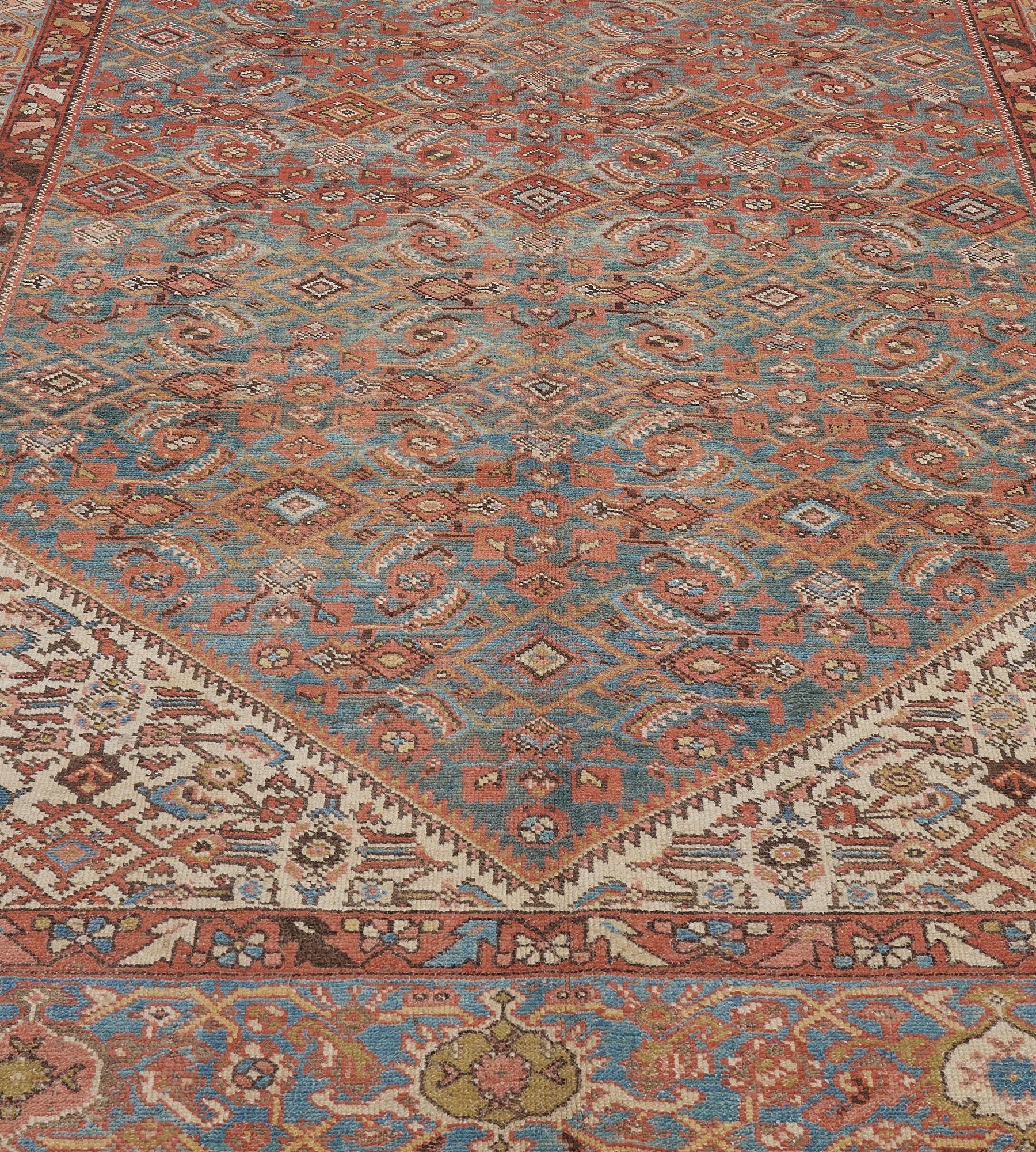This antique, circa 1900, Persian Malayer runner has a light blue field with an overall brick-red and ivory herati-pattern, the ivory spandrels similar, in a light-blue field of polychrome turtle-palmette vine between brick-red floral vine stripes.