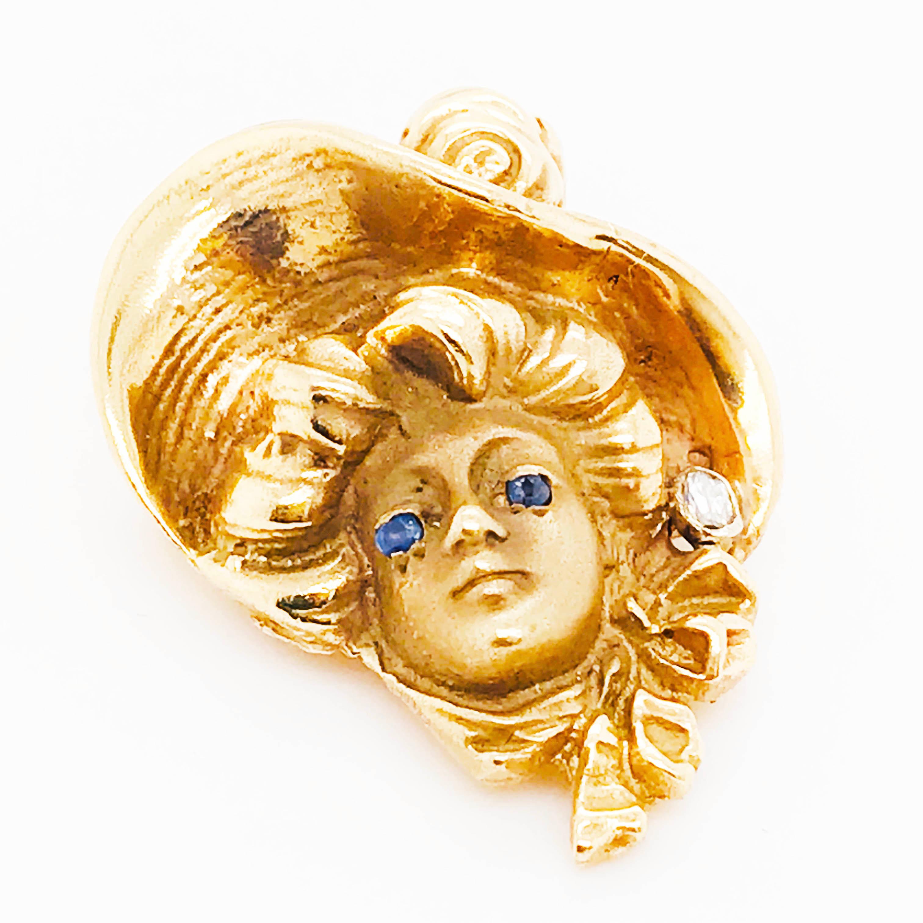This beautiful woman brooch is a symbol of the Art Nouveau era! She has captivating round sapphire gemstones eyes set in rich yellow gold. The 3-dimensional woman figure has wispy, full, flowing hair that's romantic in design. Set in the left side