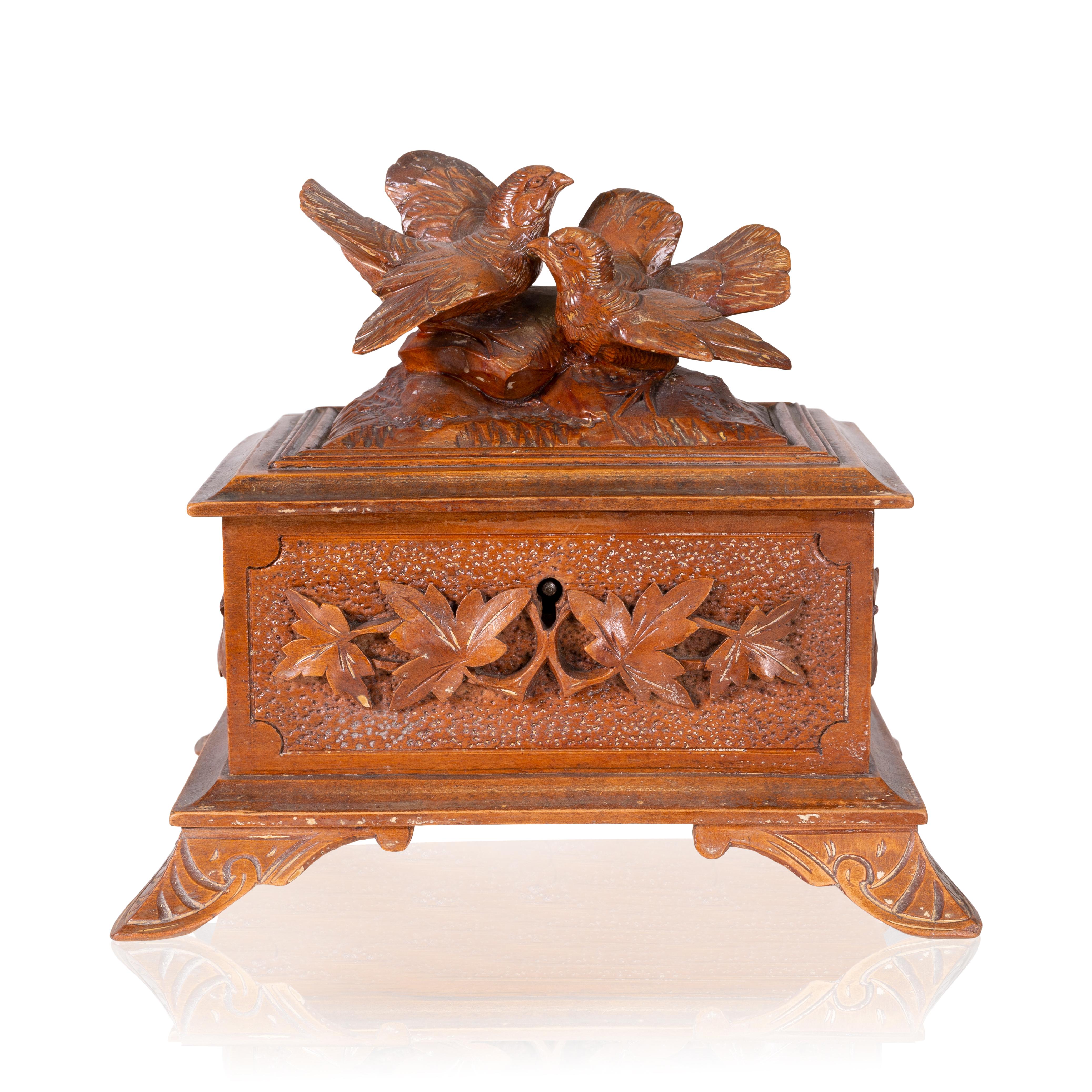 Magnifique boîte à bijoux sculptée à la main en Forêt Noire, avec deux oiseaux chanteurs comme fleurons. Livré avec la clé originale. Une trouvaille unique. 

Origine : Suisse, vers 1900 

Dimensions : 6