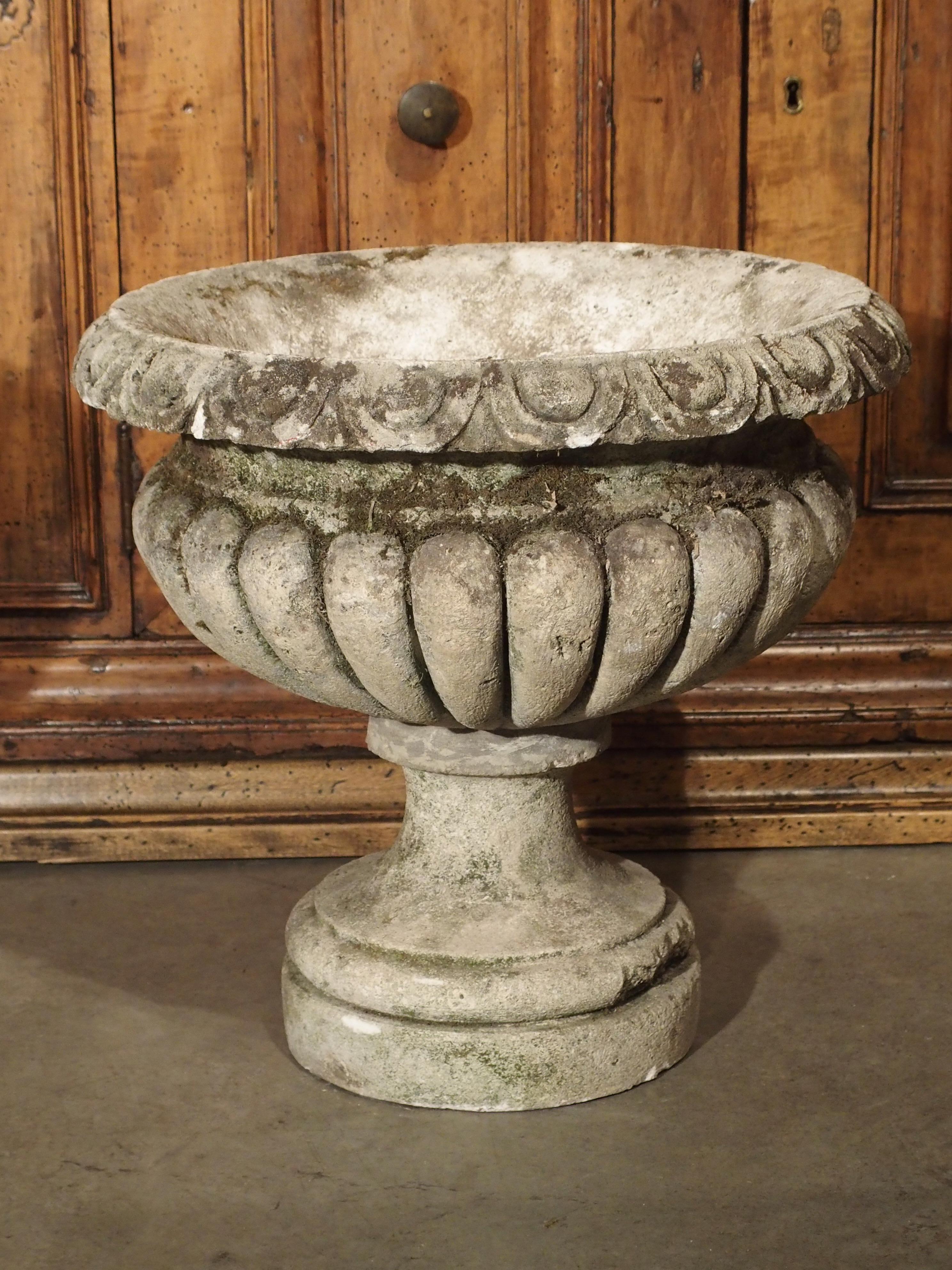 These elegant, low, campana urns are from Italy are hand carved from Northern Italian limestone. They are roughly 120 years old and feature deeply carved and large gadroons encircling each vase. The rims are also carved with classical decor,