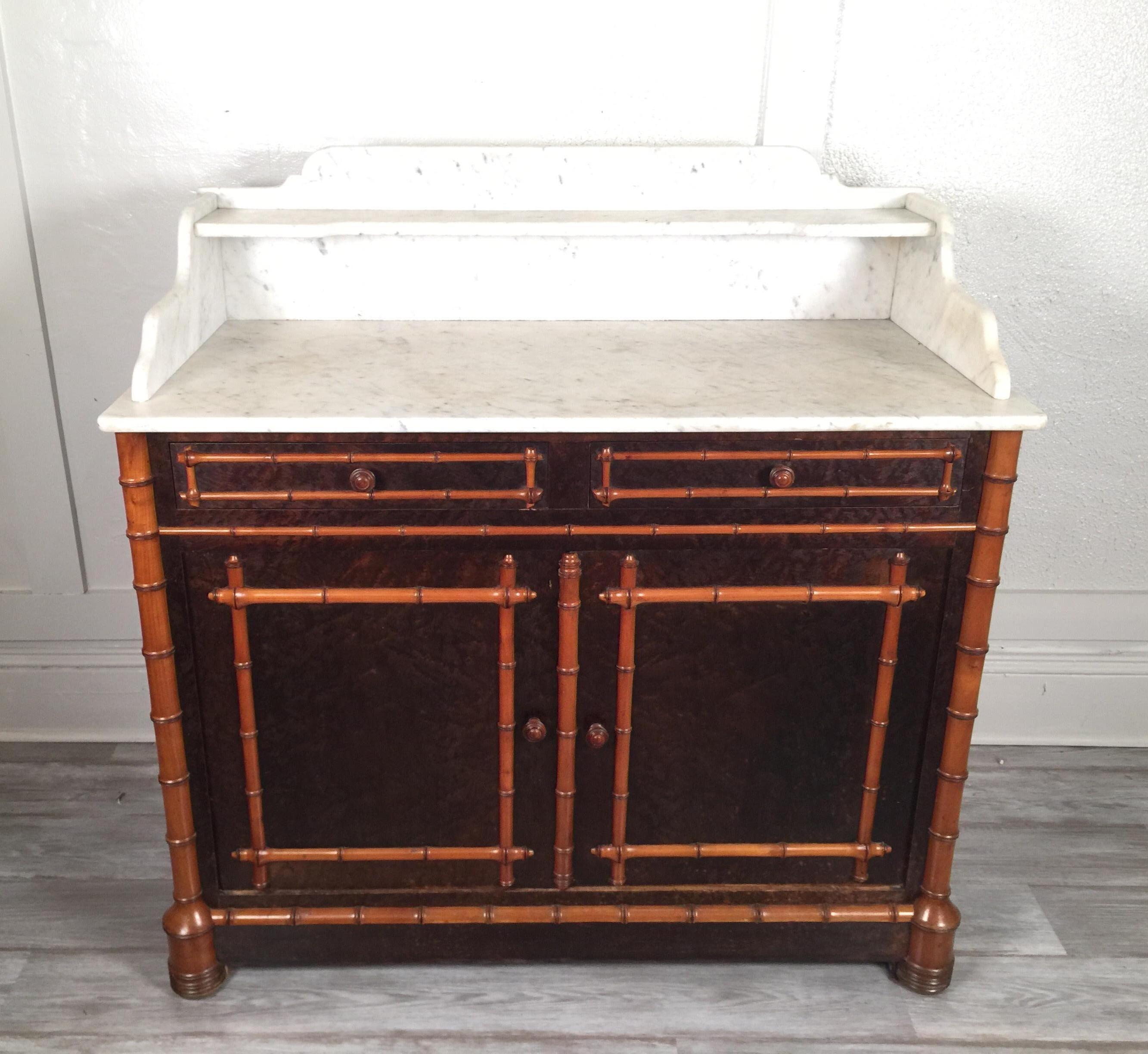 Carved wood faux bamboo two-tier marble-top cabinet, dry bar, with two drawers and two doors and shelves, circa 1900. Great piece with many uses including as a dry bar.
Dimensions: 42