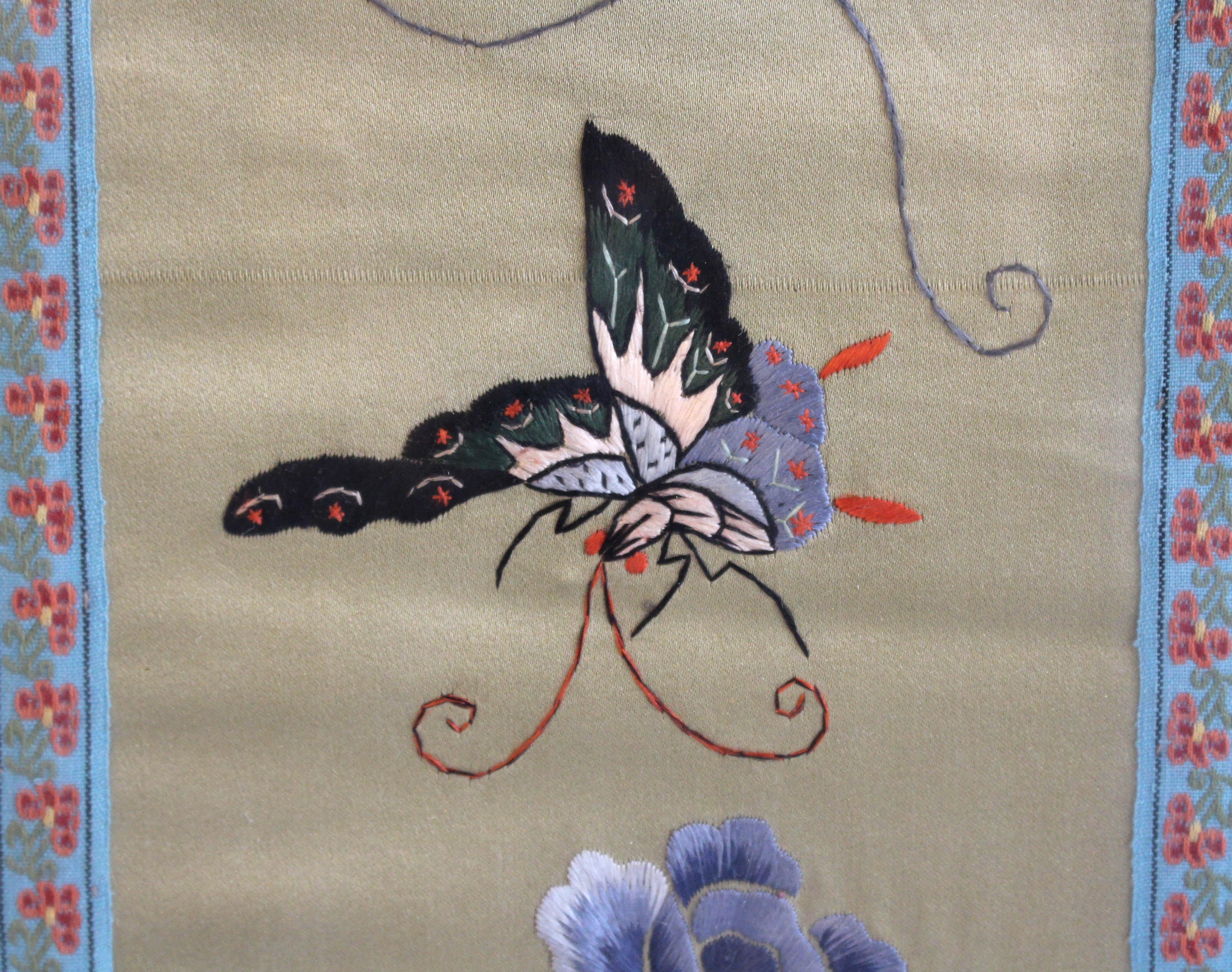 Circa 1900 Chinese silk panel in frame. Qing dynasty. Decorated with flowers & a large butterfly with silk matts & borders. Likely from a sleeve or other garment piece. 26 3/8