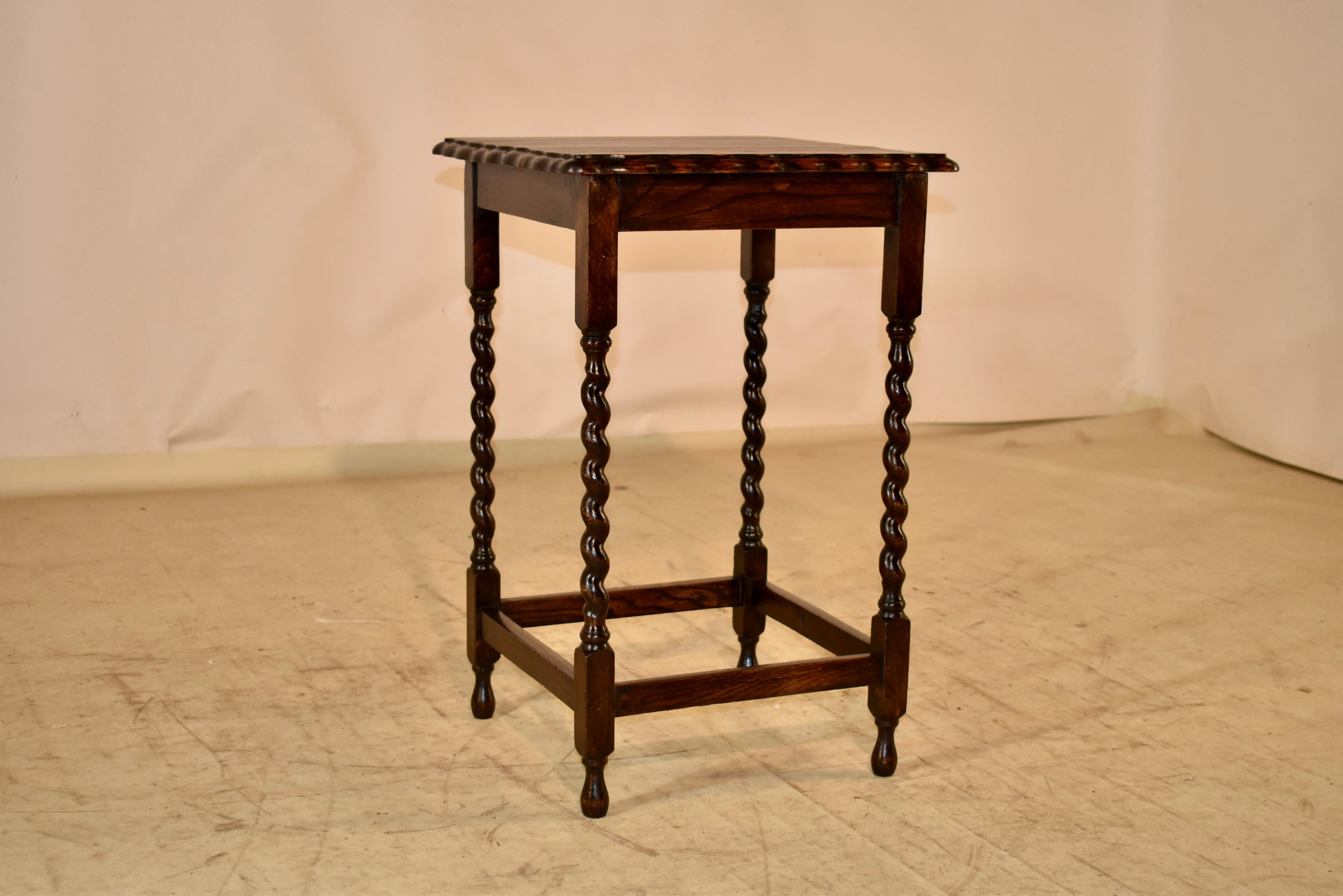 Circa 1900 Edwardian oak side table from England. The top has wonderful graining and is surrounded by a scalloped and beveled edge.  The top is over a simple apron and the table is supported on hand turned barley twist legs, joined by simple