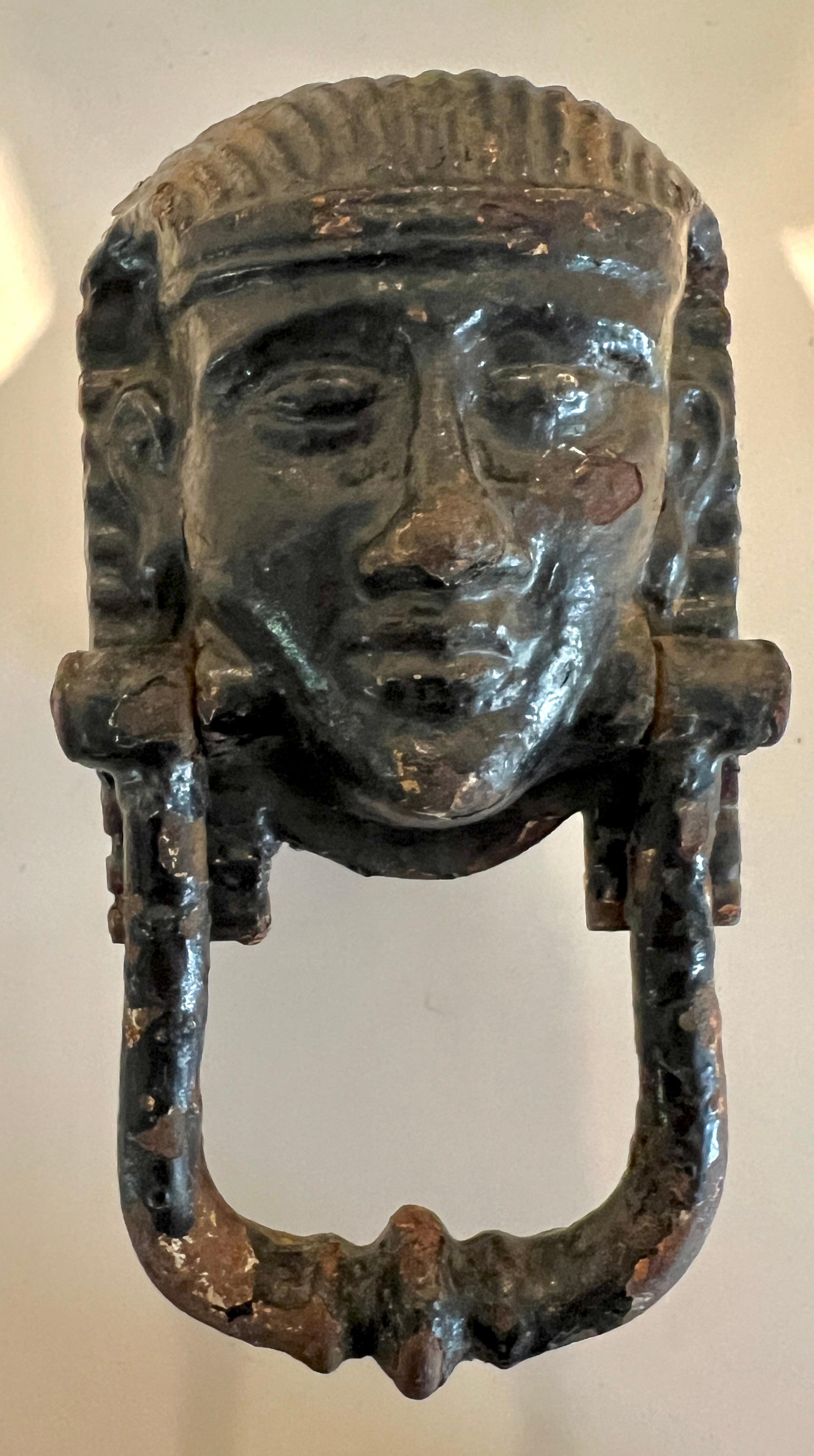 Cast Iron Door Knocker, circa 1900, London England.  

The cast iron knocker is heavily patinated and in the shape of a a Pharoah Head.  Acquired in the days when King Tutankhamun was at high popularity in Europe.  A compliant to many doors - from