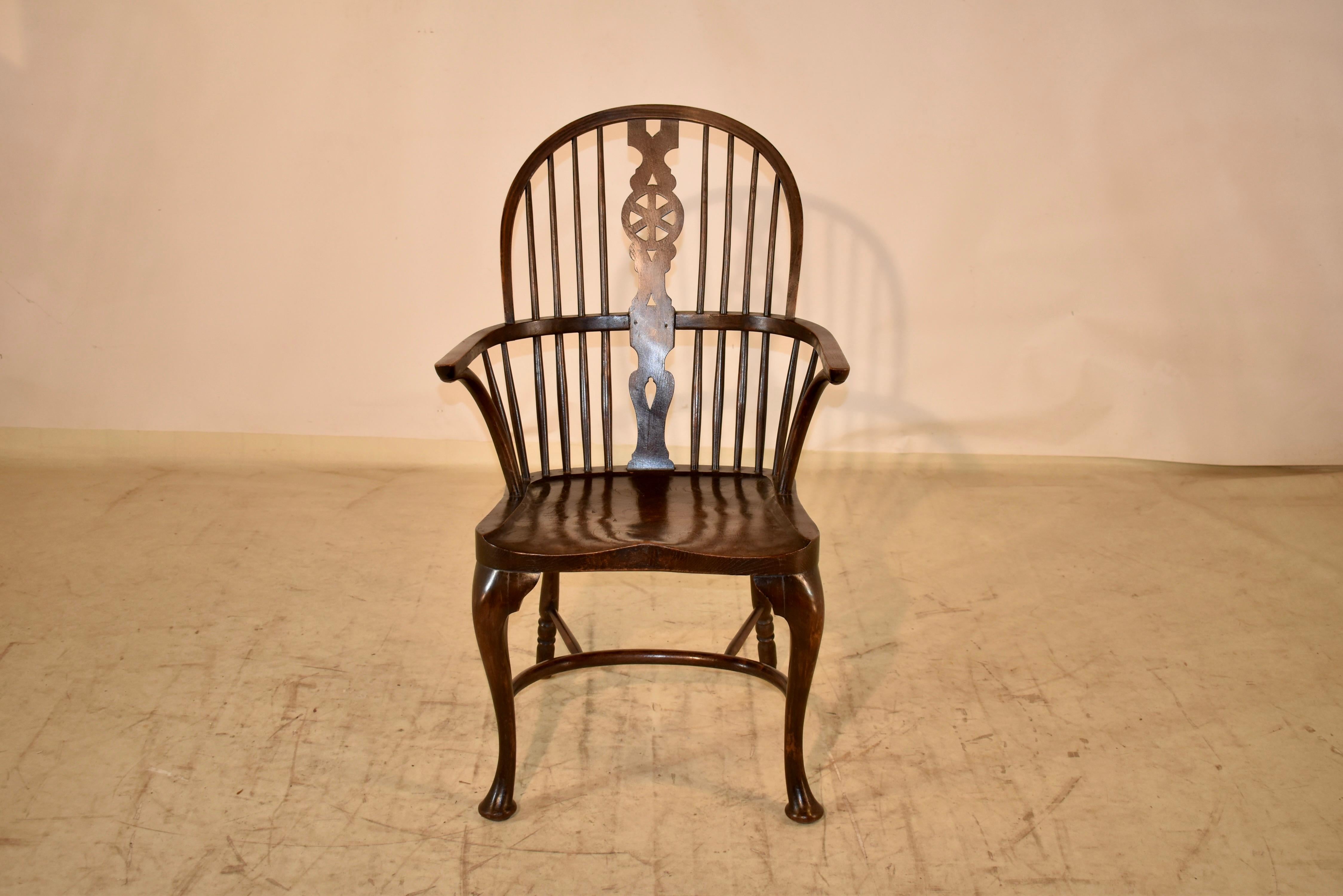 Circa 1900 Windsor armchair made from oak.  It having a double bow with a hooped spindle back and a central wheel splat flanked by spindles, over a saddled elm seat standing on front cabriole legs and turned back legs joined by a crinoline curved
