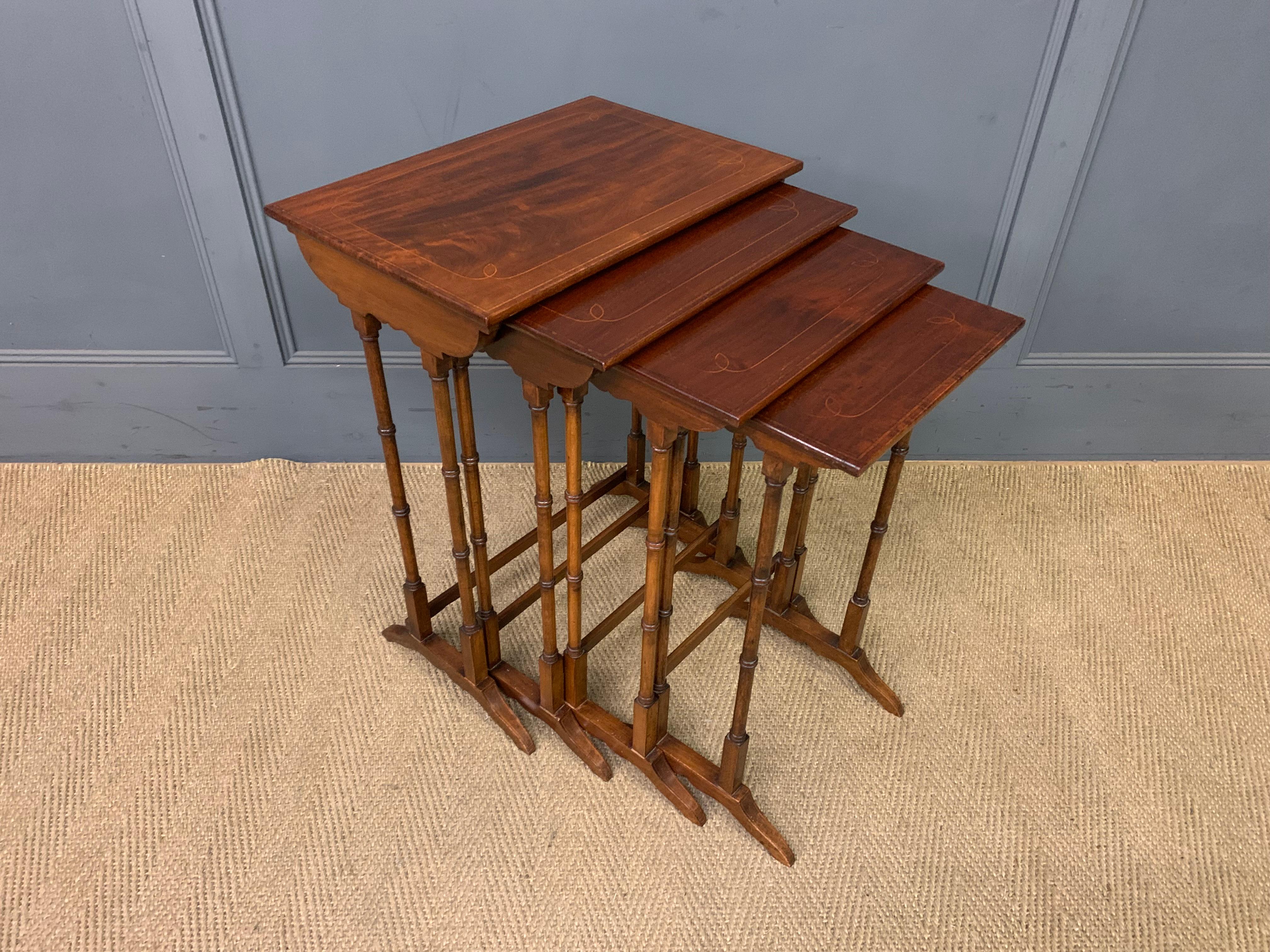 CIRCA 1900 Edwardian period set of 4 nesting tables, Englisch. Mahagoni. Gedrechselte Beine aus Bambusimitat. Geformte Schuhsohlen. Die Oberseiten mit Satinholzbändern und Maßwerk. Der größte von etwas hellerer Farbe aufgrund der stärkeren