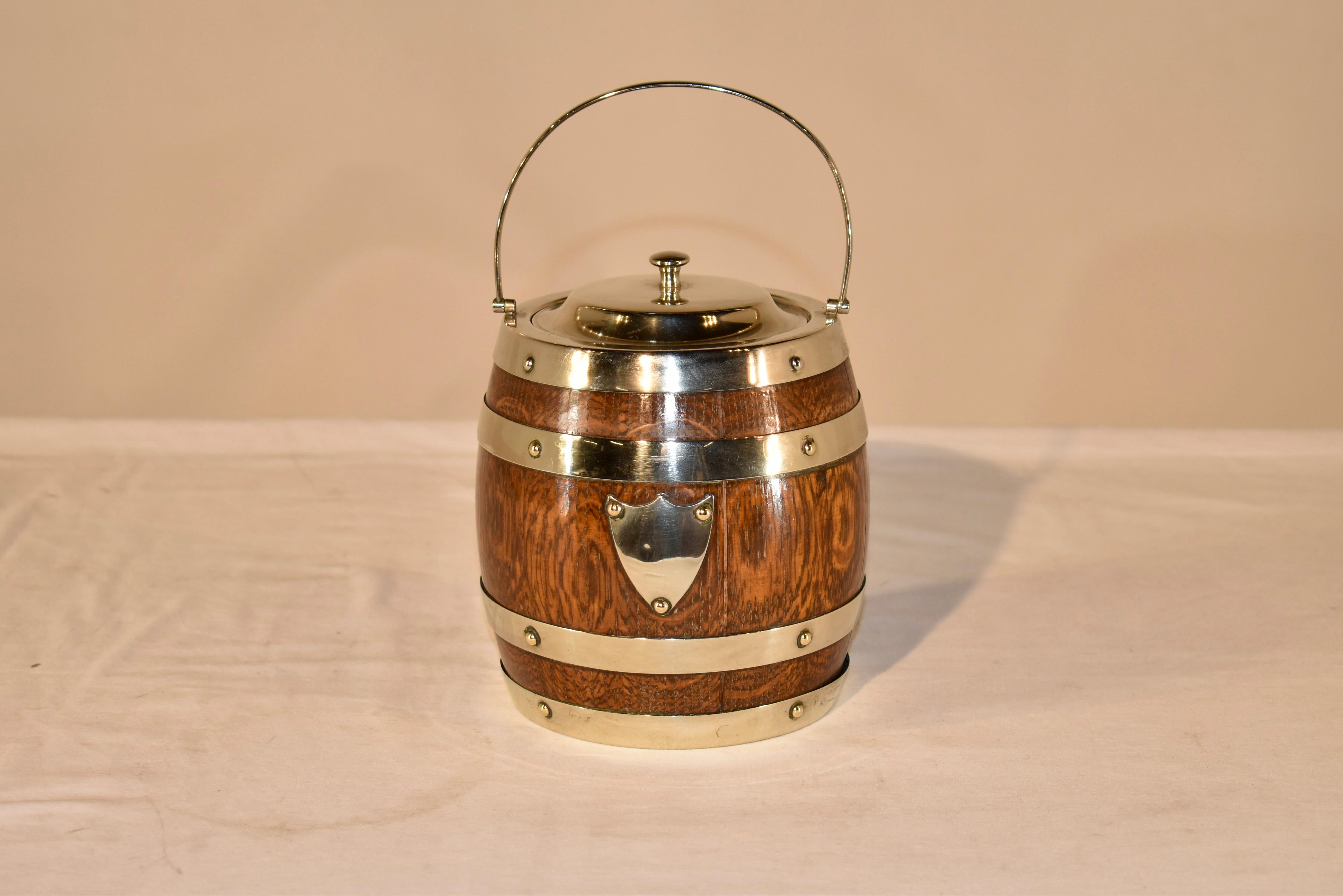Circa 1900 English oak biscuit barrel which is banded with silver plated bands.  The interior is lined in porcelain.  these are wonderful to use at a bar for ice or for items in an office or any room of the home you need small storage.