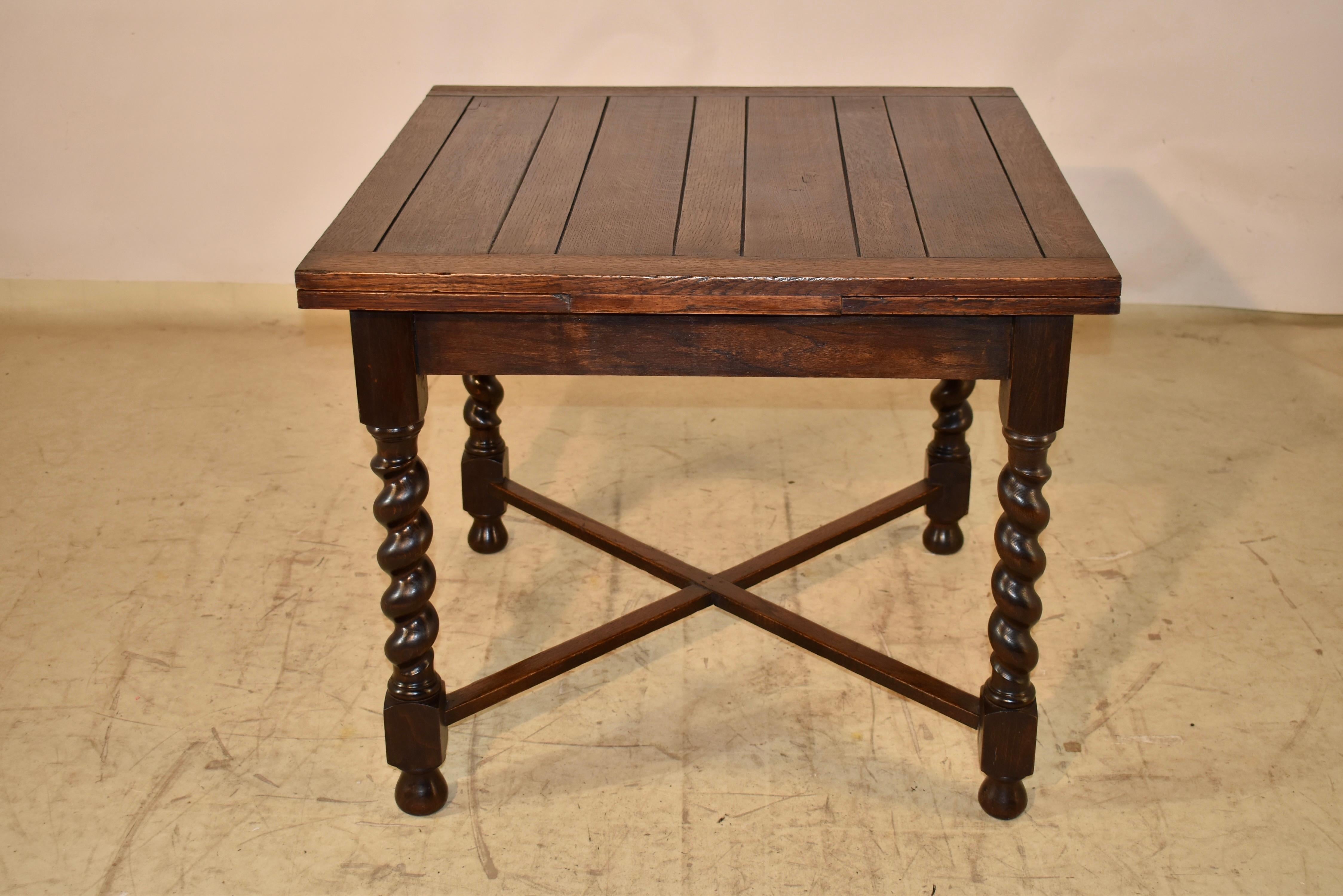 Circa 1900 oak table from England.  The top is paneled and has two draw leaves which extend to measure 58 inches in length.  The table can be used with the leaves in or extended for easy placement in any home or office.  The top follows down to a