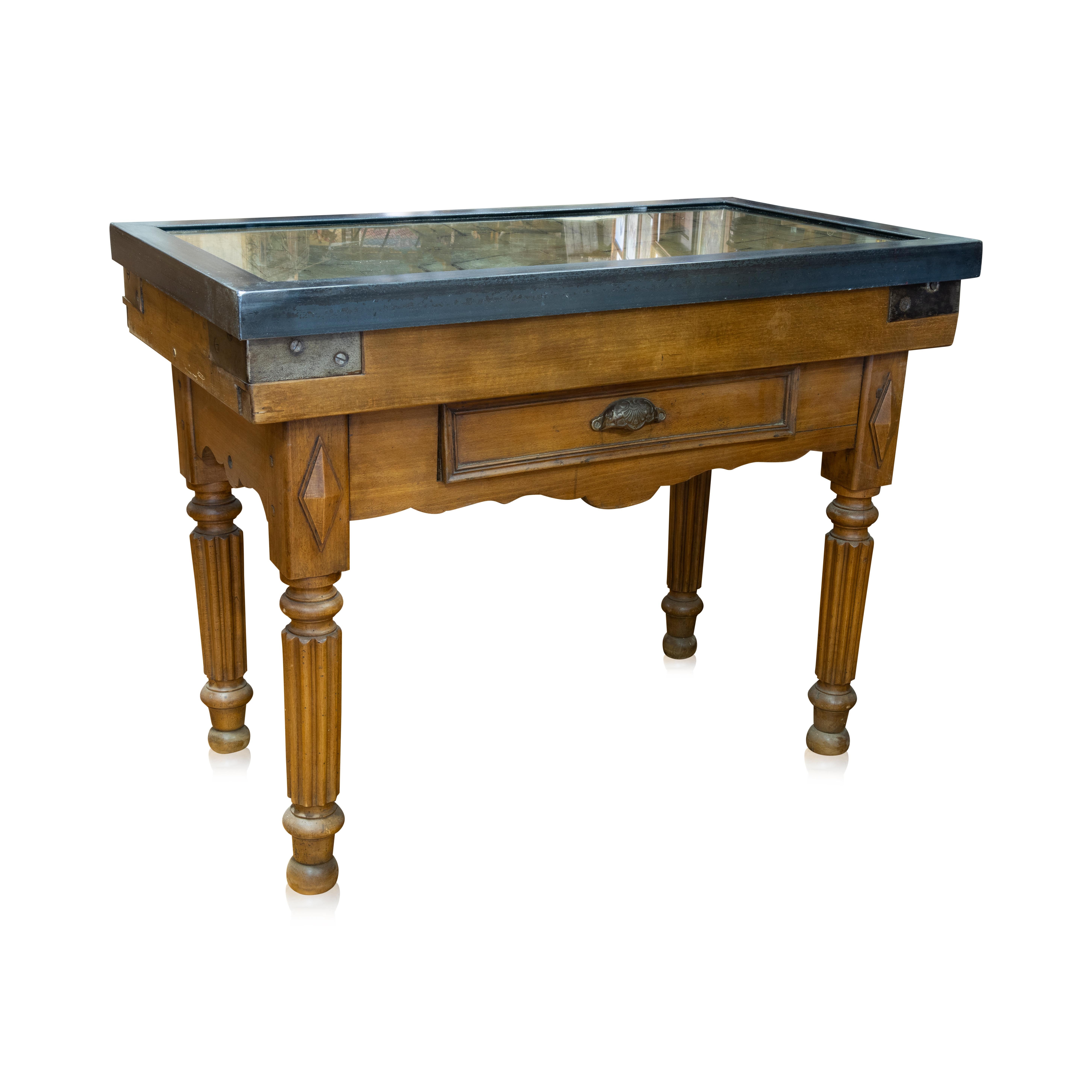 Well patinated French provincial butcher block with reinforced metal corners, drawer and fluted legs. We added burnish iron frame with glass to make functional.

Period: Early 20th Century

Origin: France

Size: 39 1/2