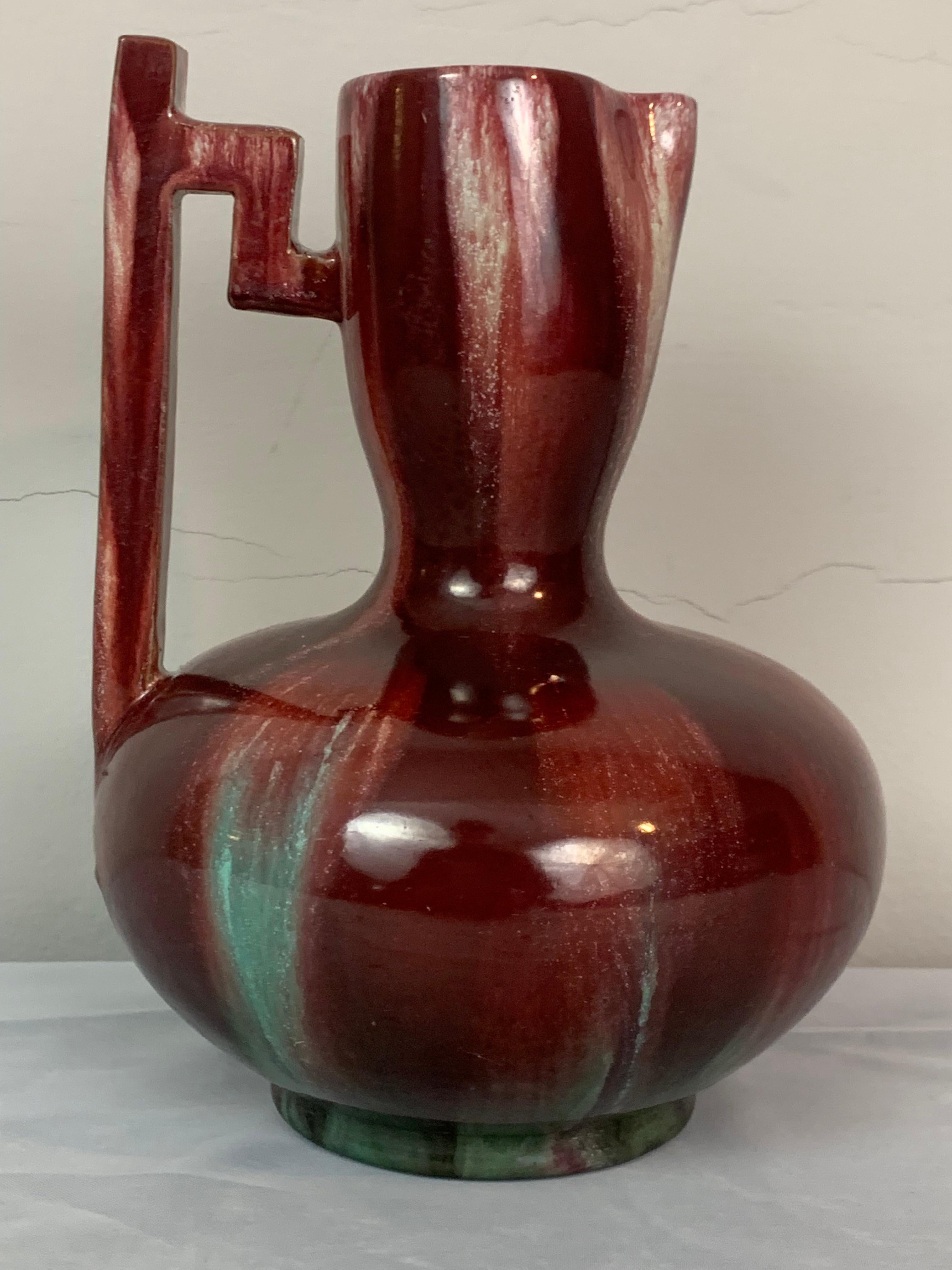 Circa 19th century French Art Nouveau ceramic earthenware jug or vase by Clément Massier. The vase features a wonderful glaze with a trickle down effect of white and turquoise over an ox blood base. The wonderful angled handled sits on one side of