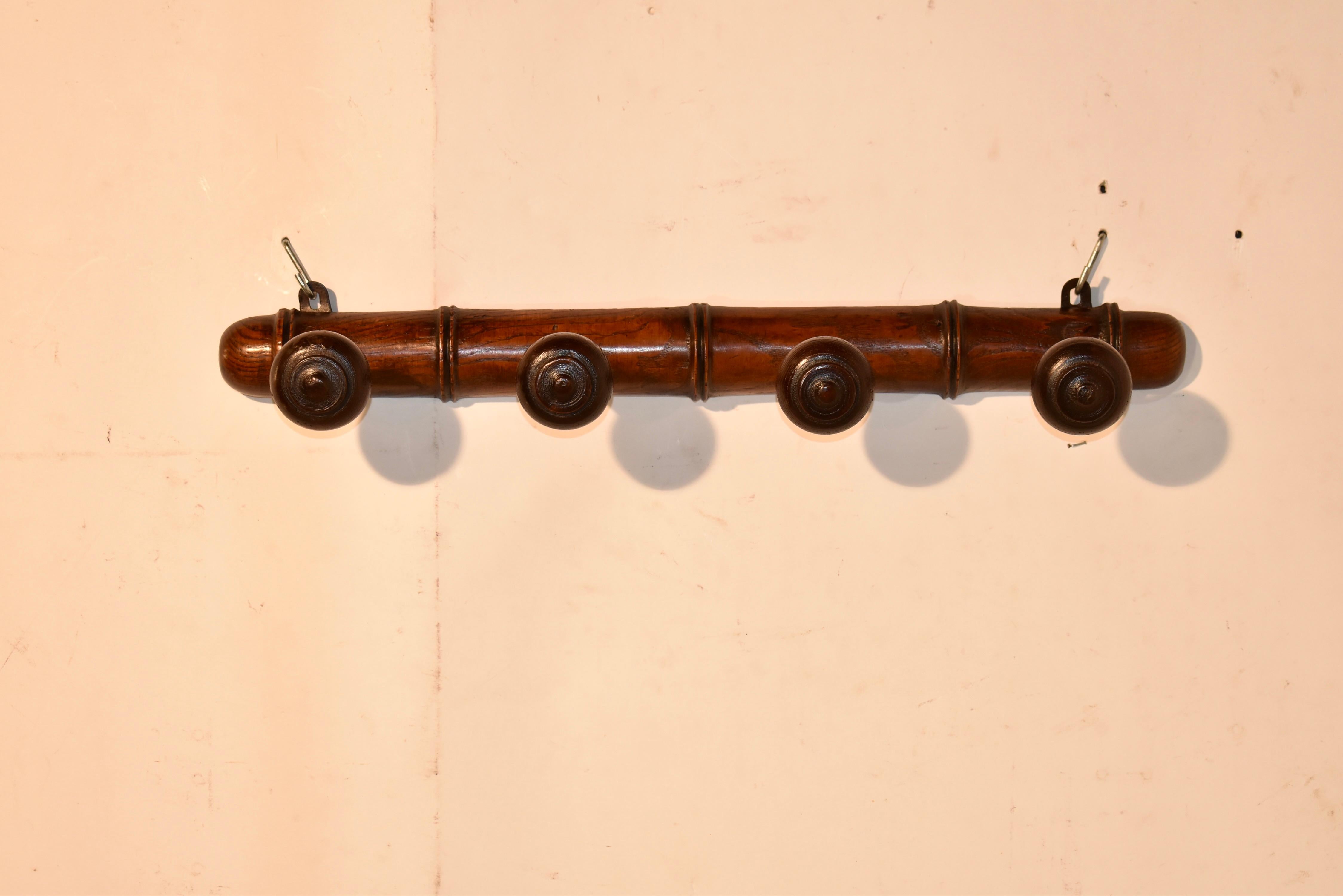 CIRCA 1900 Französischer Hut- oder Garderobenständer zum Aufhängen an der Wand.  Das Regal ist aus Ulme gefertigt und hat eine wunderschöne Maserung.  Es gibt vier handgedrehte Heringe zum Aufhängen und der Sockel ist ebenfalls handgedreht, um das
