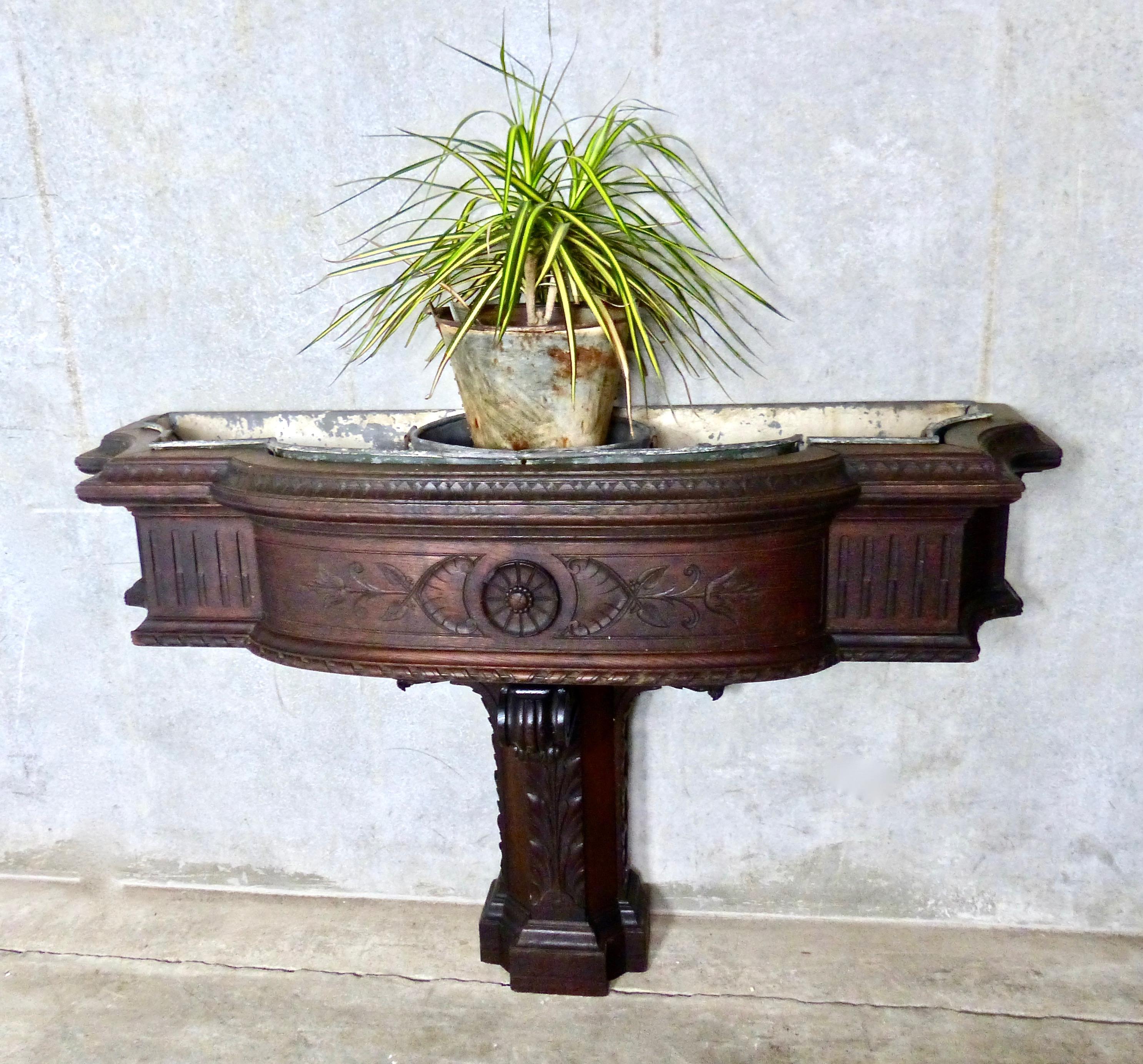 Indoor, wall-mounted plant stand. Hand made from oak, with intricately carved details, circa 1900. Includes original zinc liners for plants. A rare English -made piece with a wonderful patina.
retains original finish
Dimensions 37 H” x 56 W” x 17