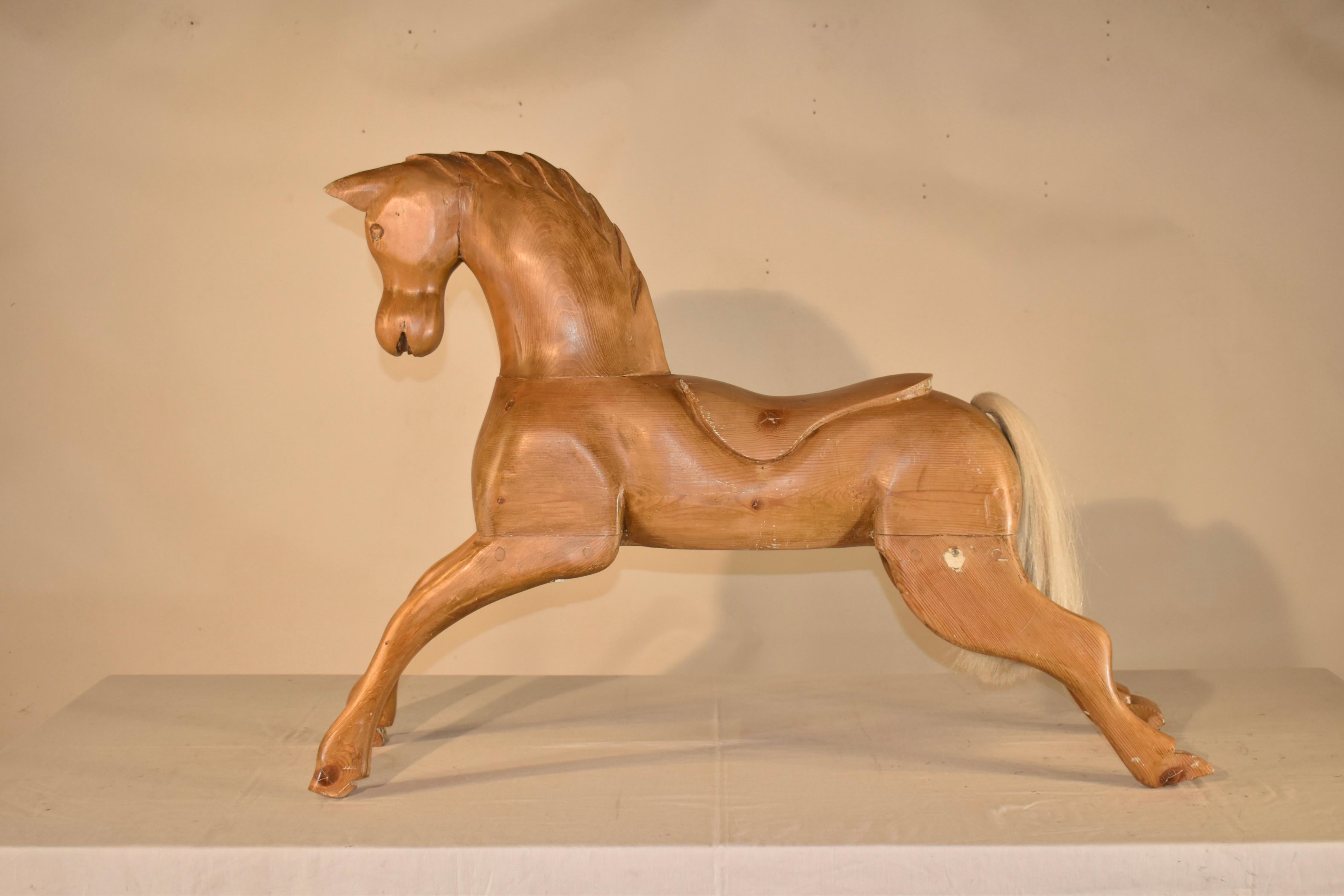 Cavallo di pino intagliato a mano del 1900 circa.  Si tratta di un meraviglioso pezzo d'arte popolare, che potrebbe essere stato uno splendido cavallo a dondolo quando è stato realizzato.  Il cavallo è stato dipinto un tempo, dato che ci sono ancora