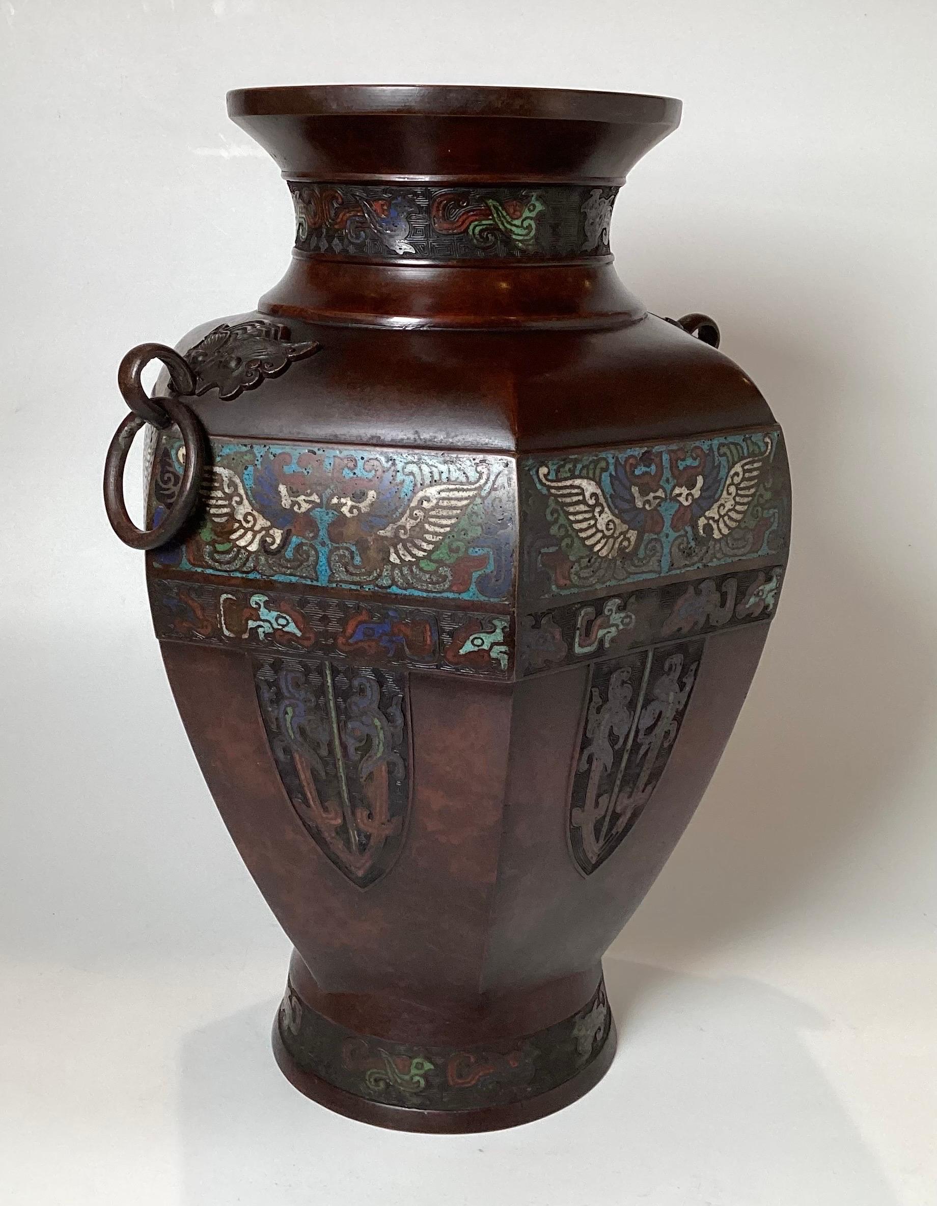 Circa !900 Japanese Large well shaped bronze champleve enameled vase.. 
Six paneled sides with Asian themed engravings on each panel.With two ringed handles. Original warm amber brown patina.