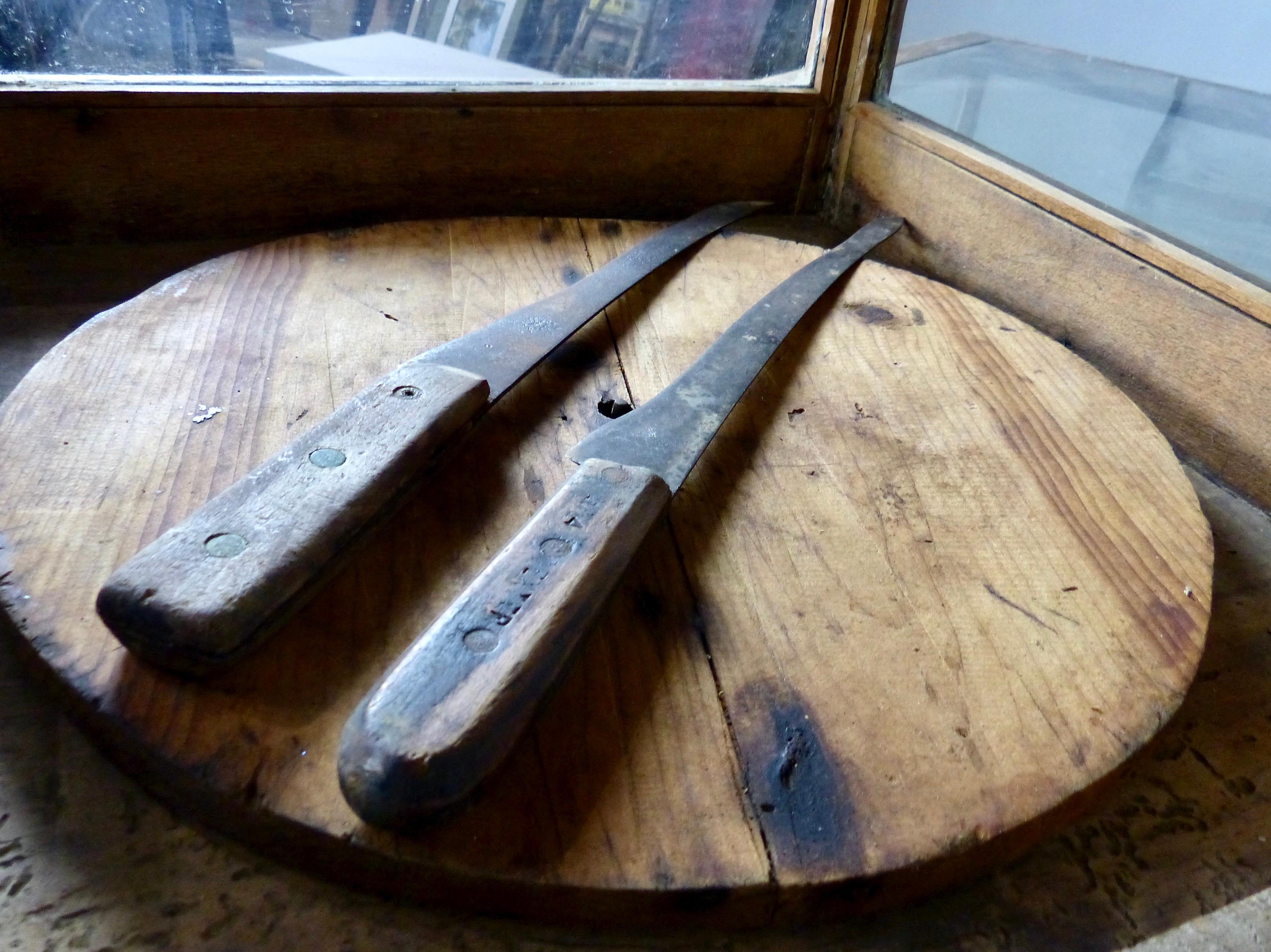 A glass-panelled, solid oak framed display cabinet for cheese. The circa 1900 merchandising unit includes the original cheese wheel (which can be rotated by hand) along with two early cheese knives. Base and top of the cabinet are solid wood; the