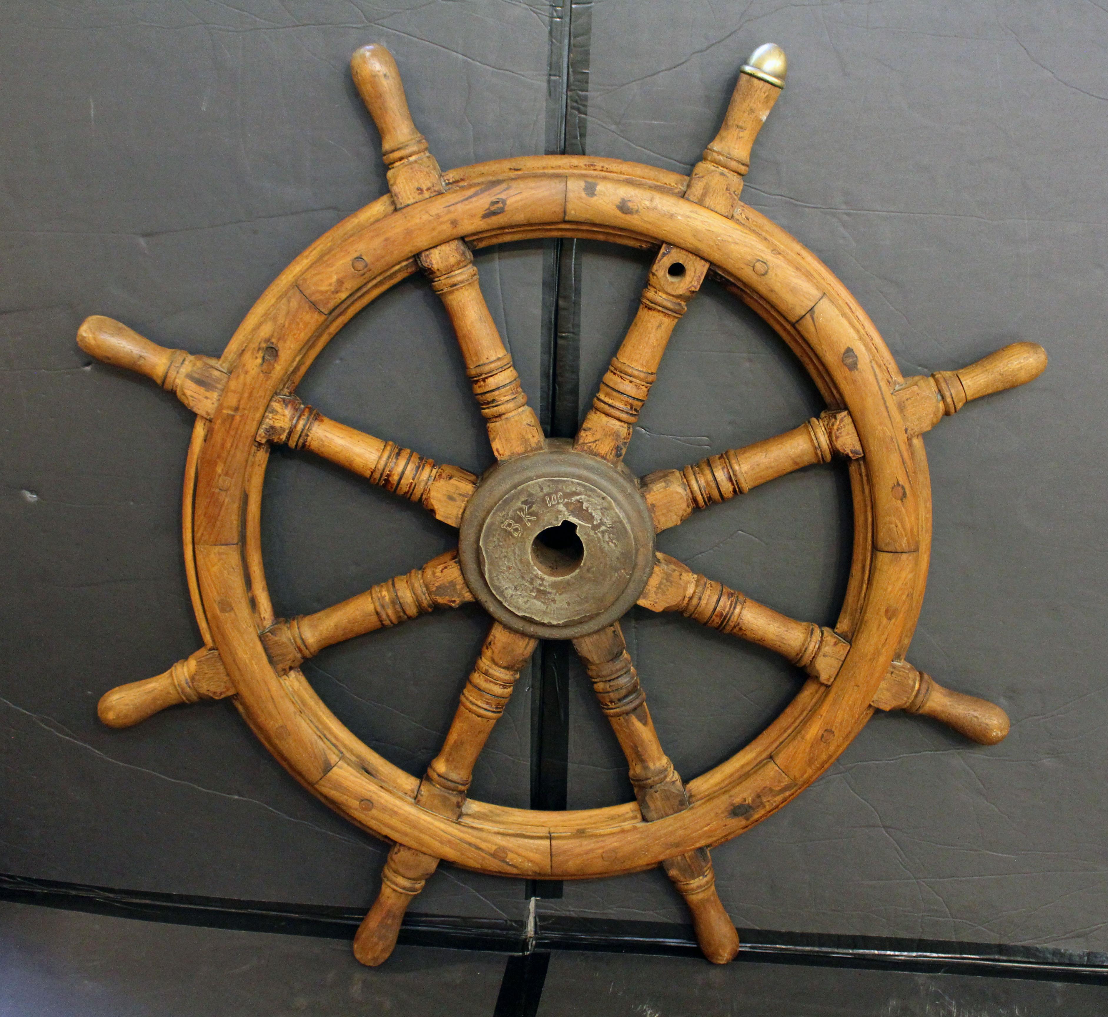 Roue de bateau antique, anglo-européenne, circa 1900 ou antérieure. Teck, fer et laiton. Marqué à la main : BK 100. La plaque en laiton sur le rayon semble avoir été ajoutée ultérieurement : Electr. Model Makerij & Timmerfabriek C. I.C., Slikkerveer