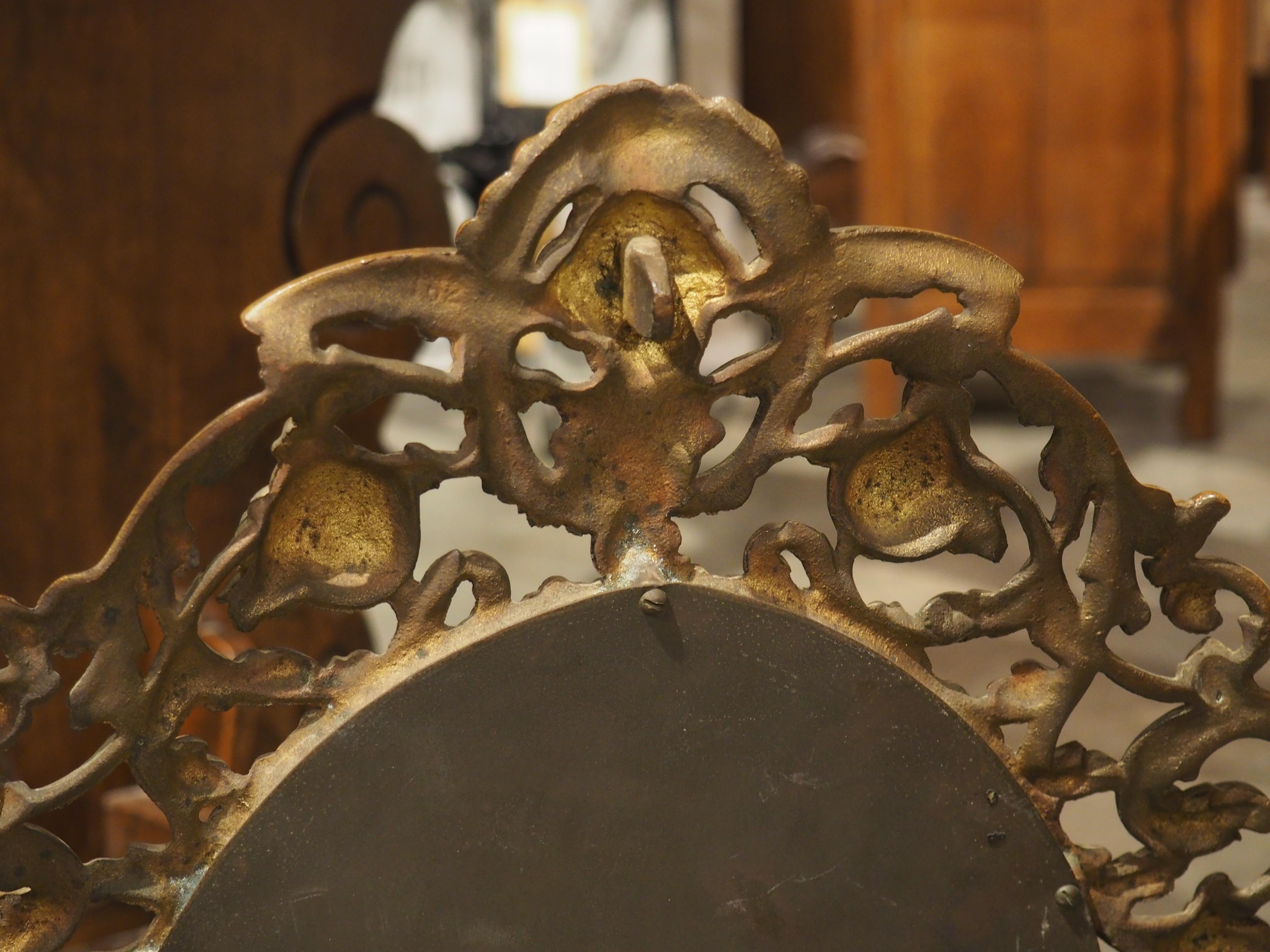 Datant d'environ 1900, ce miroir de table italien présente un petit miroir ovale entouré d'un cadre en bronze doré complexe et ajouré. Une subtile moulure de rais-de-cœur entoure immédiatement le verre, servant de point de départ à l'étalage