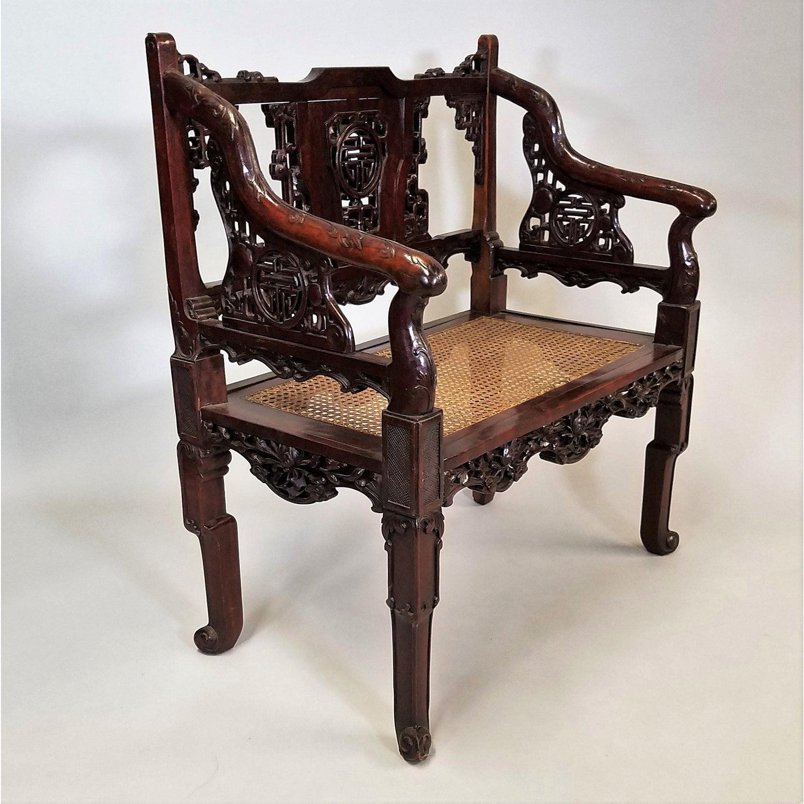 Circa 1900 Pair of Chinese Hand Carved Mahogany Armchairs. The mahogany has been stained in some areas for contrast. Seats are hand caned. The back of the chair, though, is where the true craftsmanship takes place. Hand carved, there is an intricate