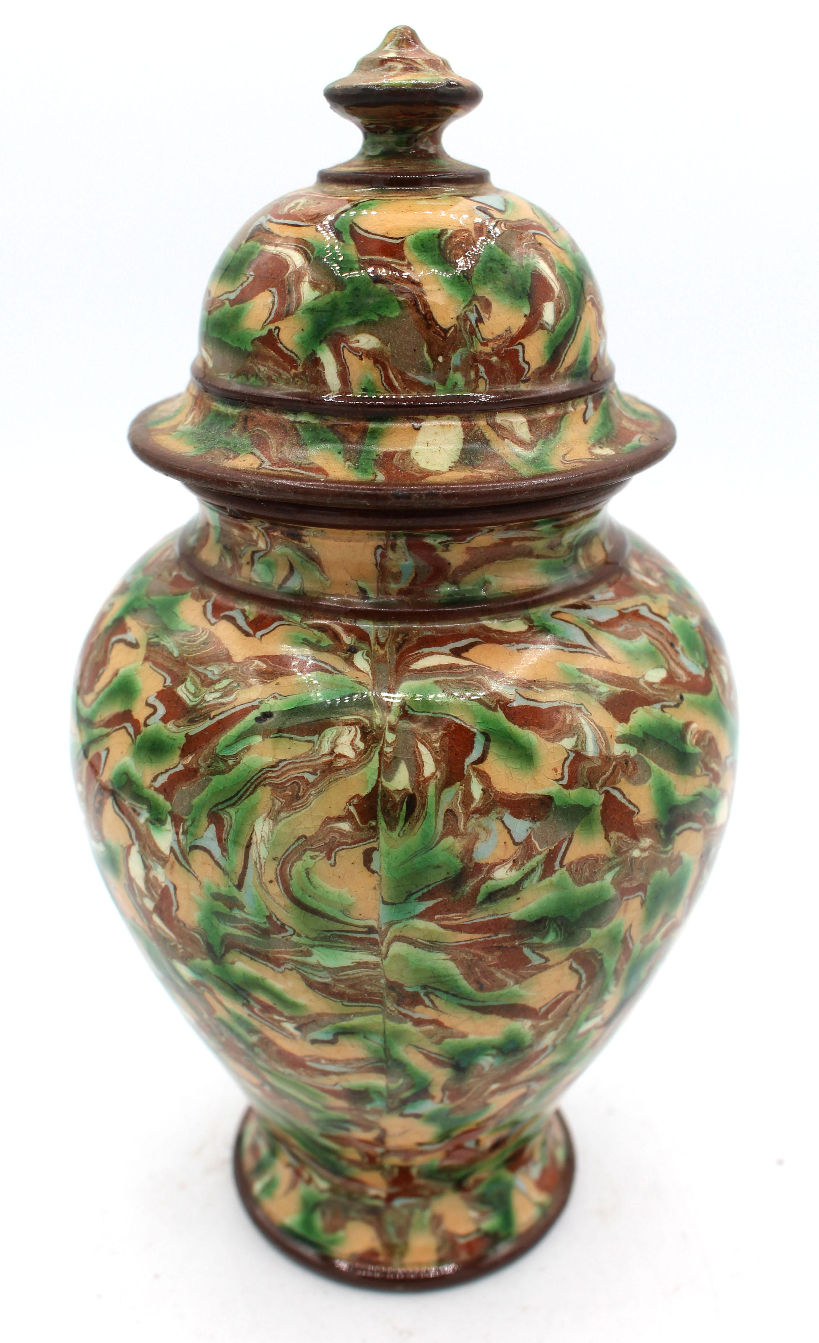 Circa 1900 terracotta covered jar, French, Maison Pichon Uzes. In Pichon's trademark marbelized glaze. The knot with minor rough spot and underside chip and the lid rim with 2 chips.
7.75