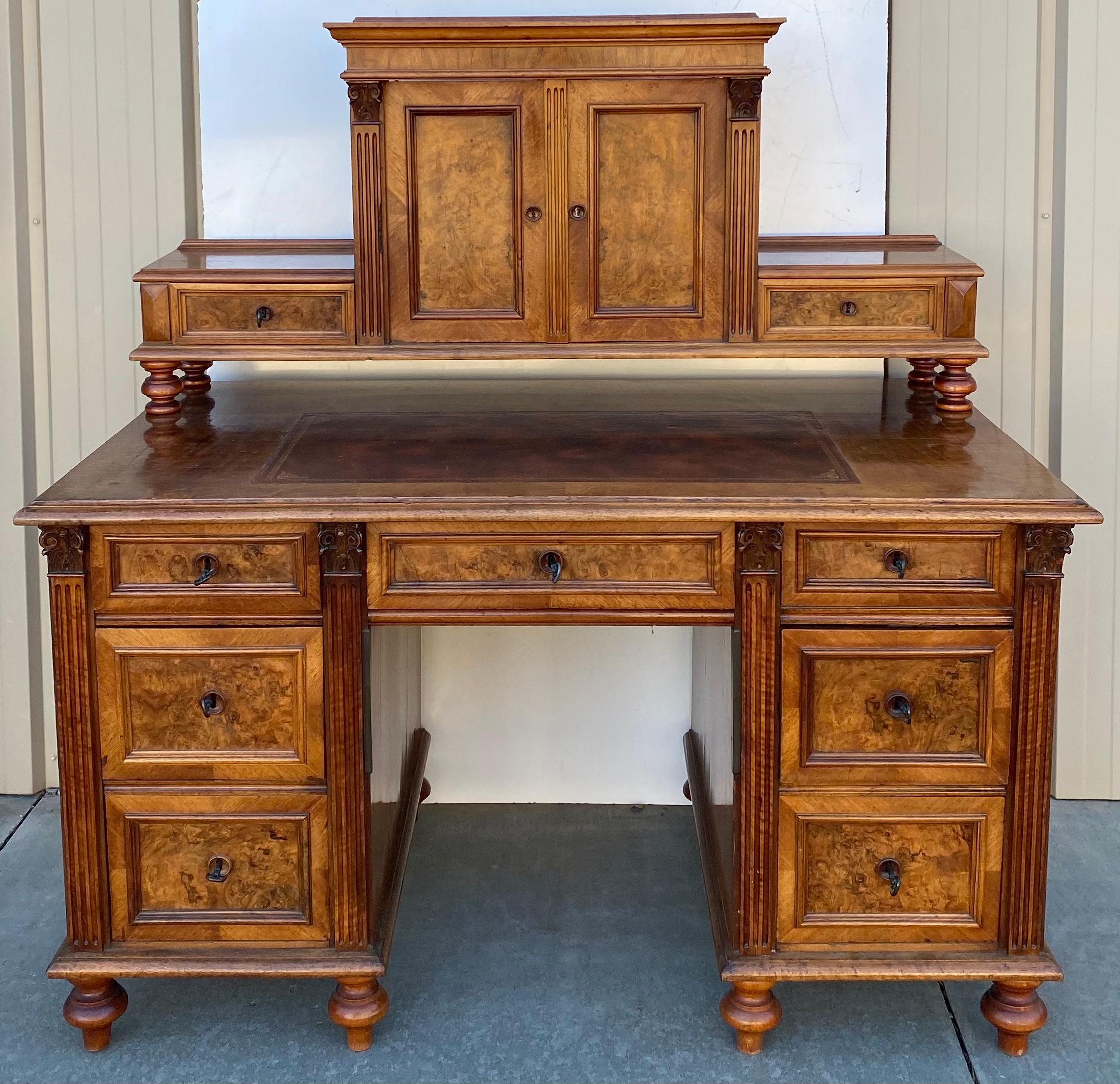 This is a turn-of-the-century Victorian Era burl walnut desk with tooled leather top. The burl is exquisite, and the overall condition is remarkable. The keys are permanently affixed in each drawer to act as pulls. The drawers have dovetail
