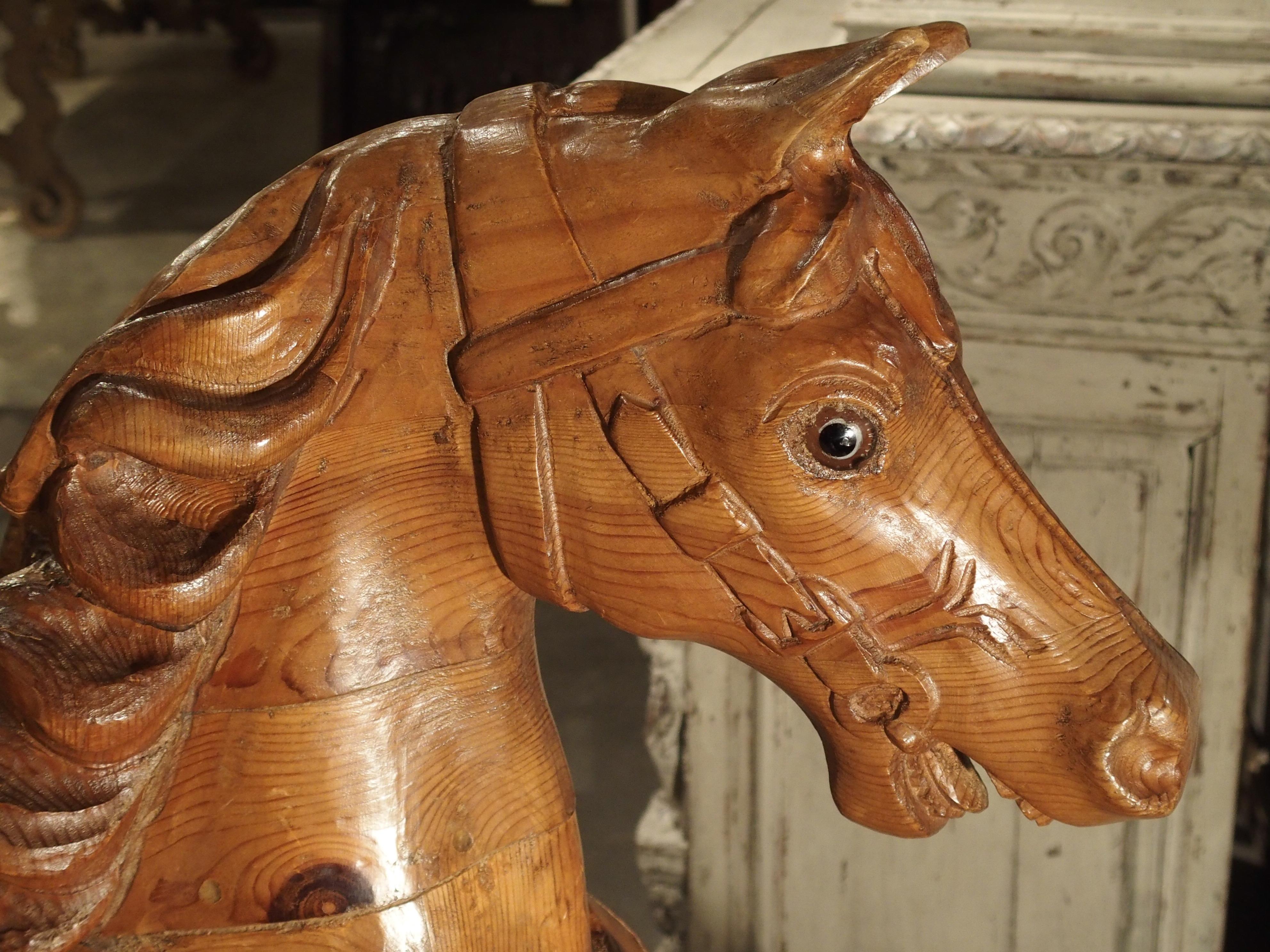 From Spain, this beautifully hand carved pine wood horse has been mounted upon a contemporary black marble stand with a black metal pole. Since there is no top hole seen on this statue, it's unlikely that it was a carousel horse. However, it may