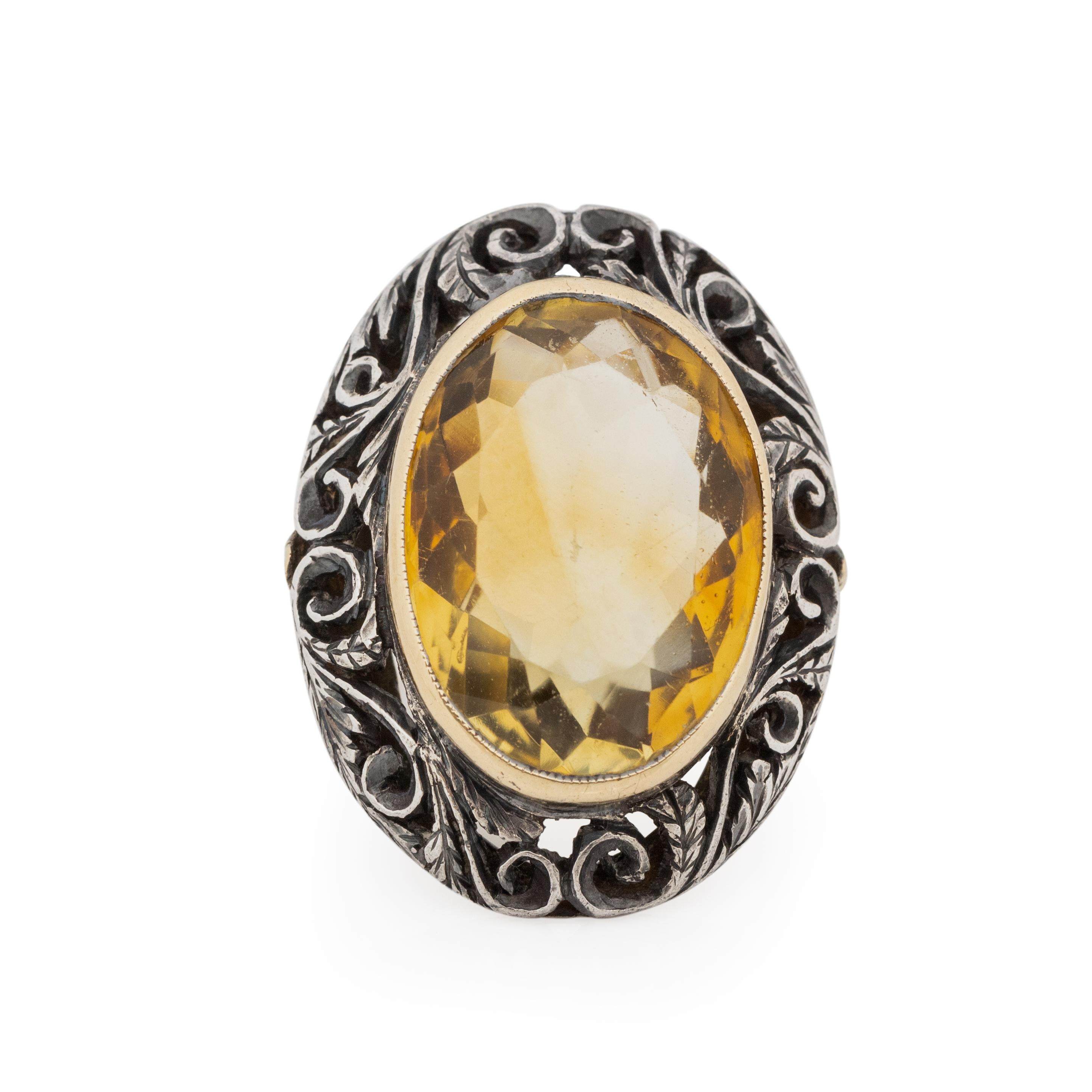 This eye catching beauty is a show stopper! Crafted in 18K yellow gold that makes up the shanks and the bezel that holds the beautiful citrine, it is also made of sterling silver. The silver is a carved halo that surrounds the gold set citrine