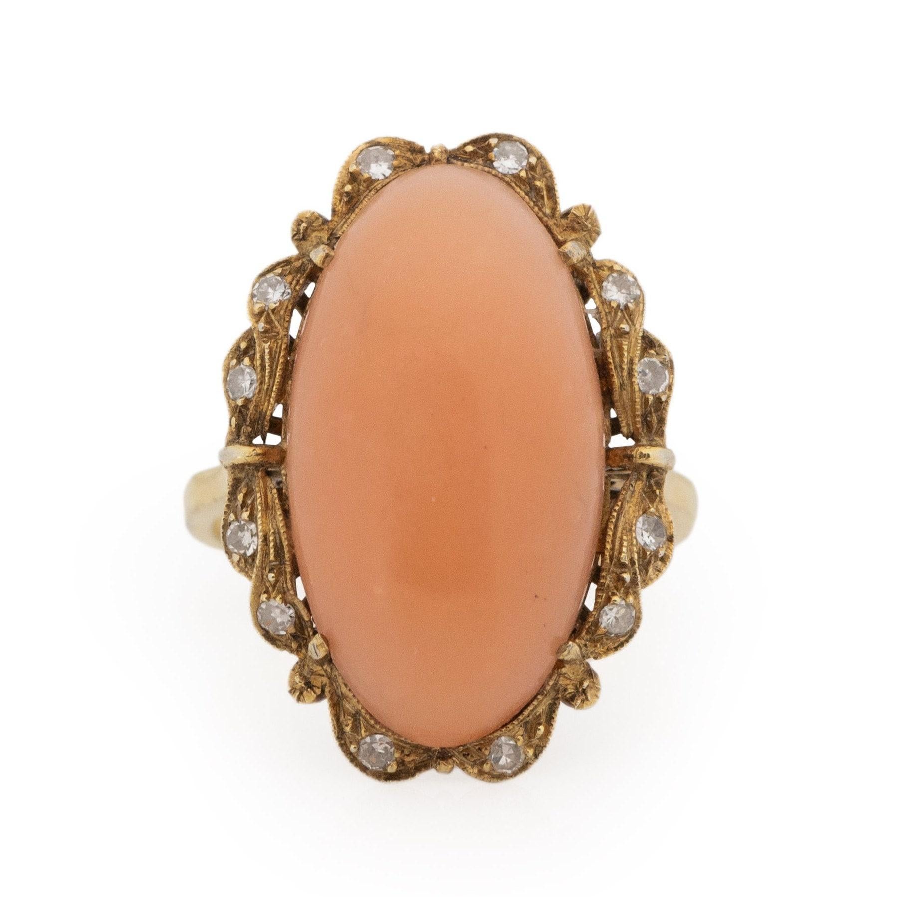 This Victorian masterpiece is meticulously crafted from opulent 18K yellow gold. The gracefully tapered shanks gently guide the gaze toward a refined gallery. Nestled within this gallery is a stunning oval cabochon coral, displaying a delicate