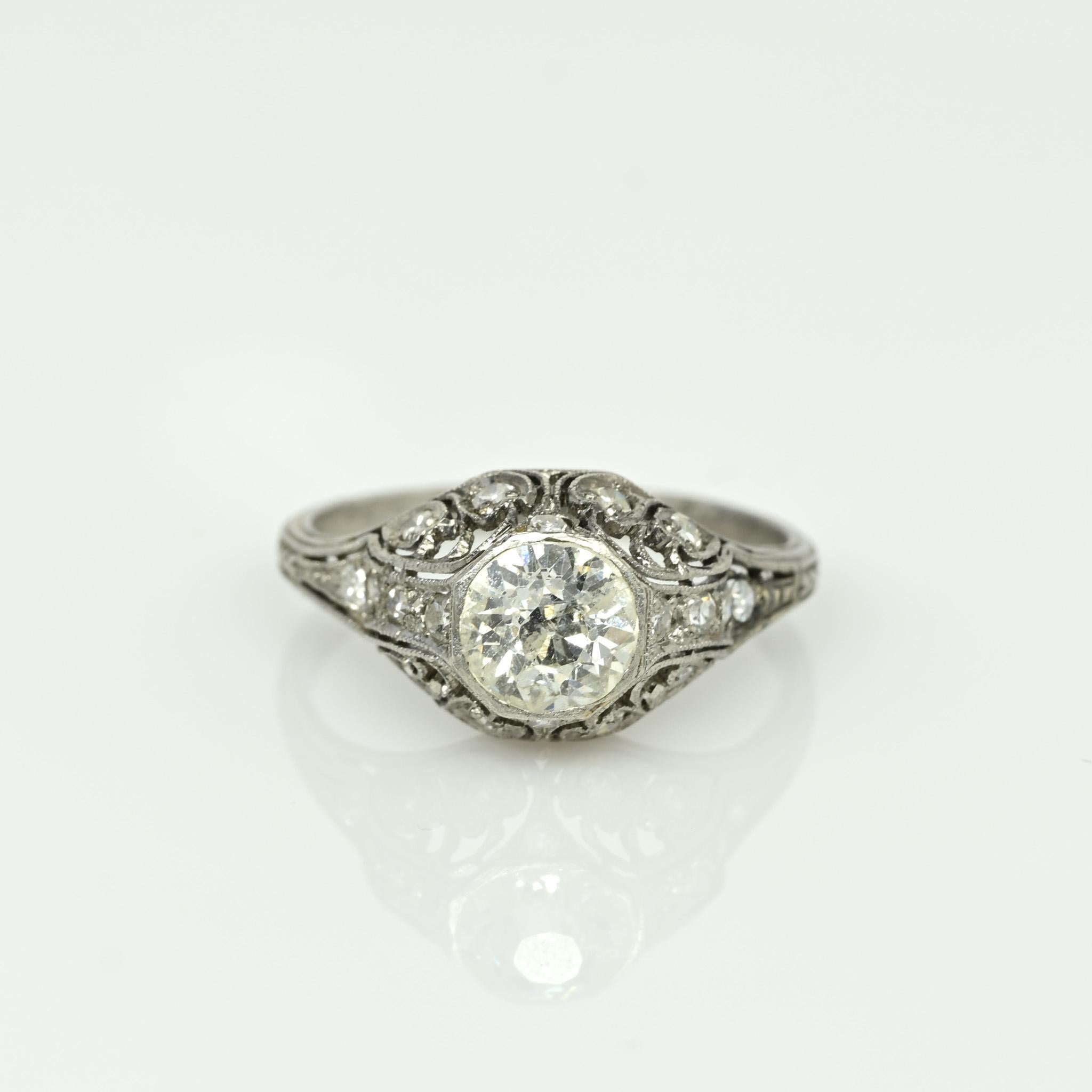 A testament to the elegance of the Edwardian era, this antique masterpiece is set in platinum and features a resplendent old European cut diamond as its centerpiece. Encircled by 16 dazzling accent diamonds, it exudes a classic Edwardian charm. The