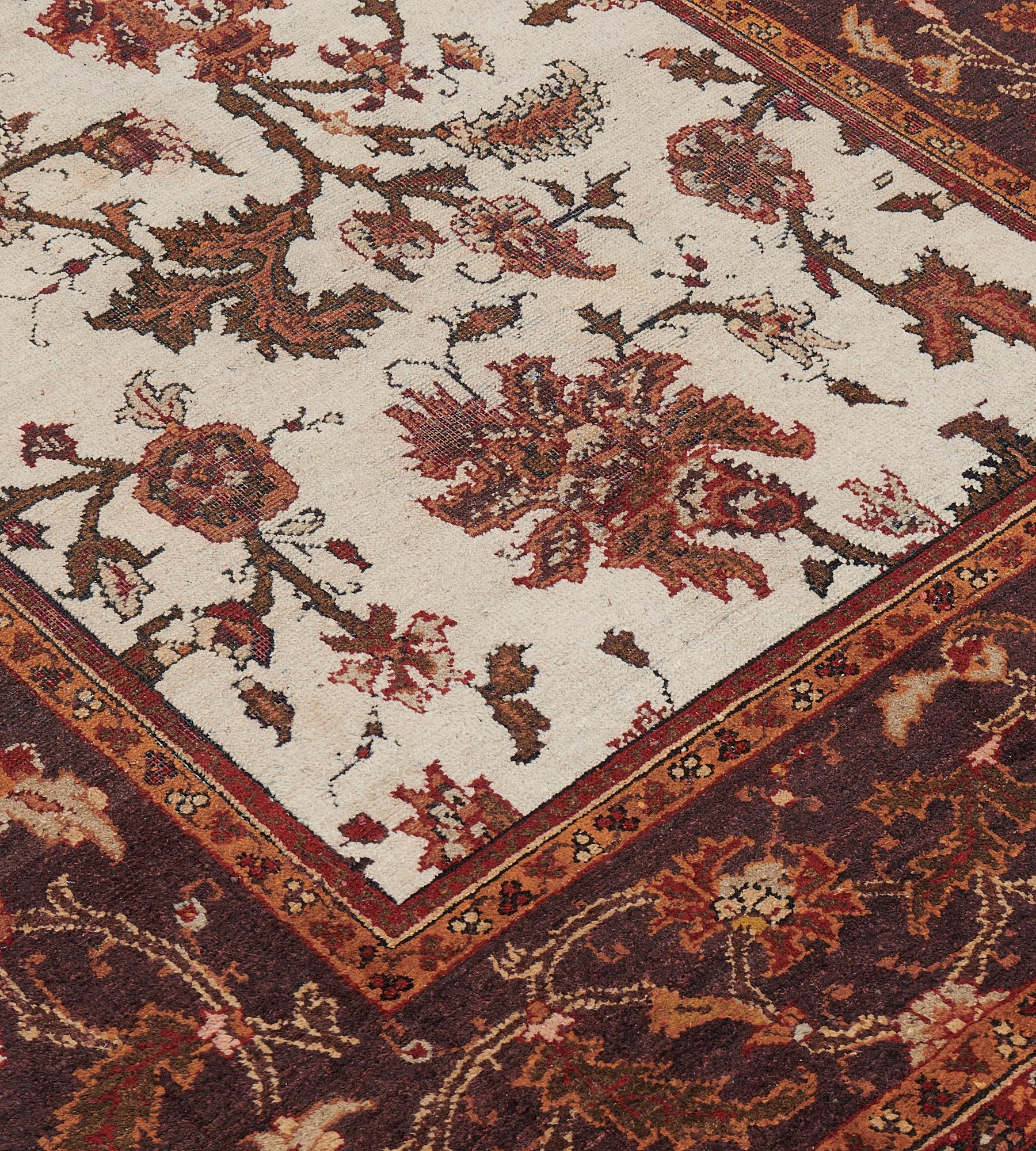 This circa 1910 runner has an ivory field with an overall design of fox brown and terracotta-red scrolling palmette and leafy vine, in a broad border of shaded vine-brown with a meandering terracotta-red and an ivory floral vine between