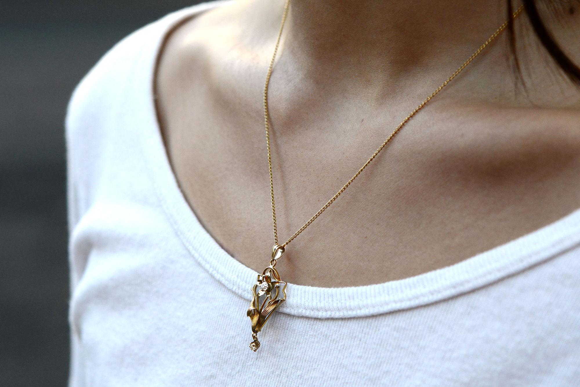 An enchanting floral pendant necklace, made during the late Art Nouveau era circa 1910. A forget-me-not flower holds a pair of old mine cut diamonds near and dear. A lovely sentimental and light-hearted statement, offering a storied farmland motif