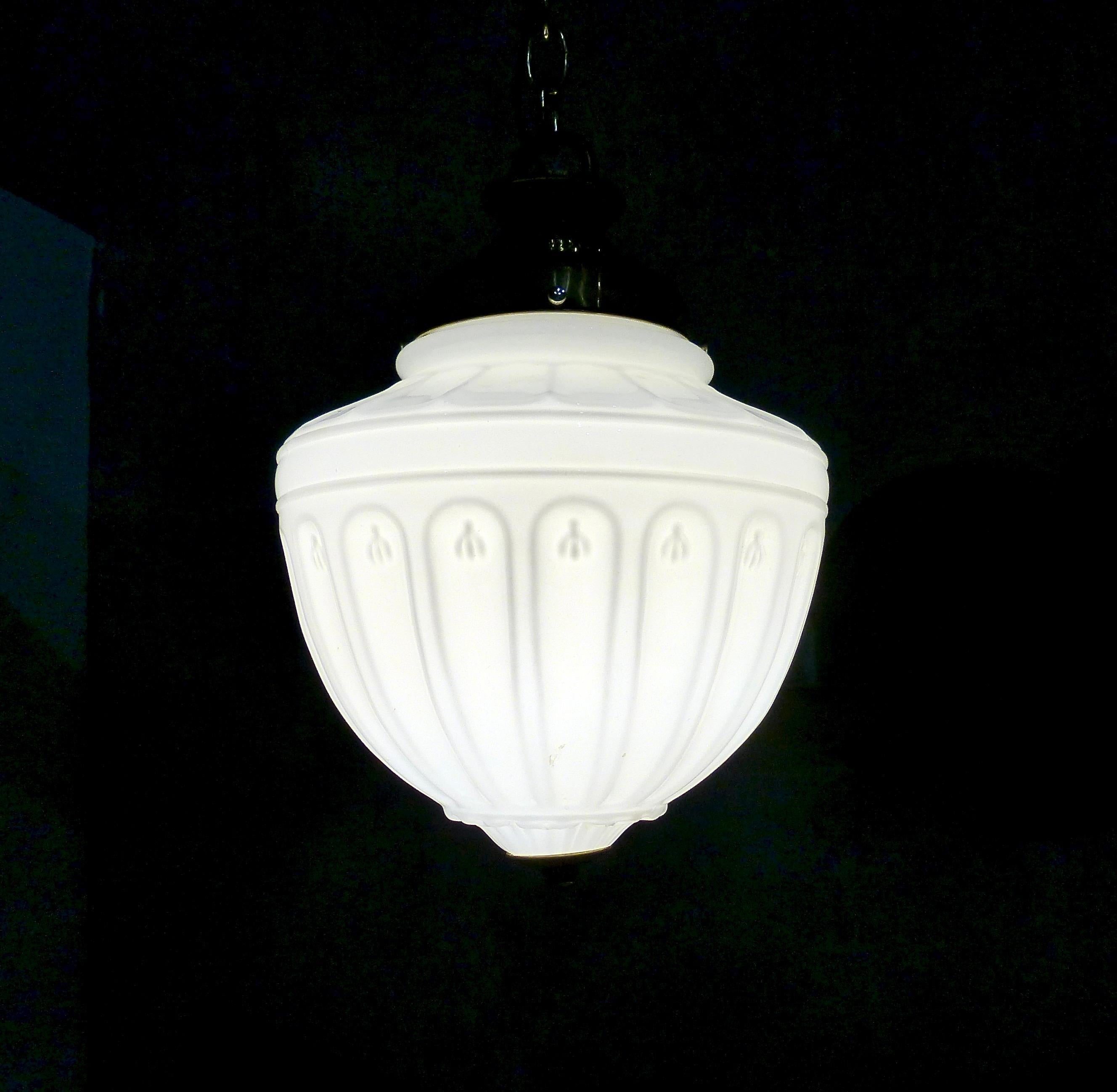A dramatic, ribbed milk glass pendant from circa 1910. Original brass fittings. Currently hangs at 36” but could be altered to suit your application. Re-wired and CSA approved to current electrical standards; ceiling mounting plate included. Only