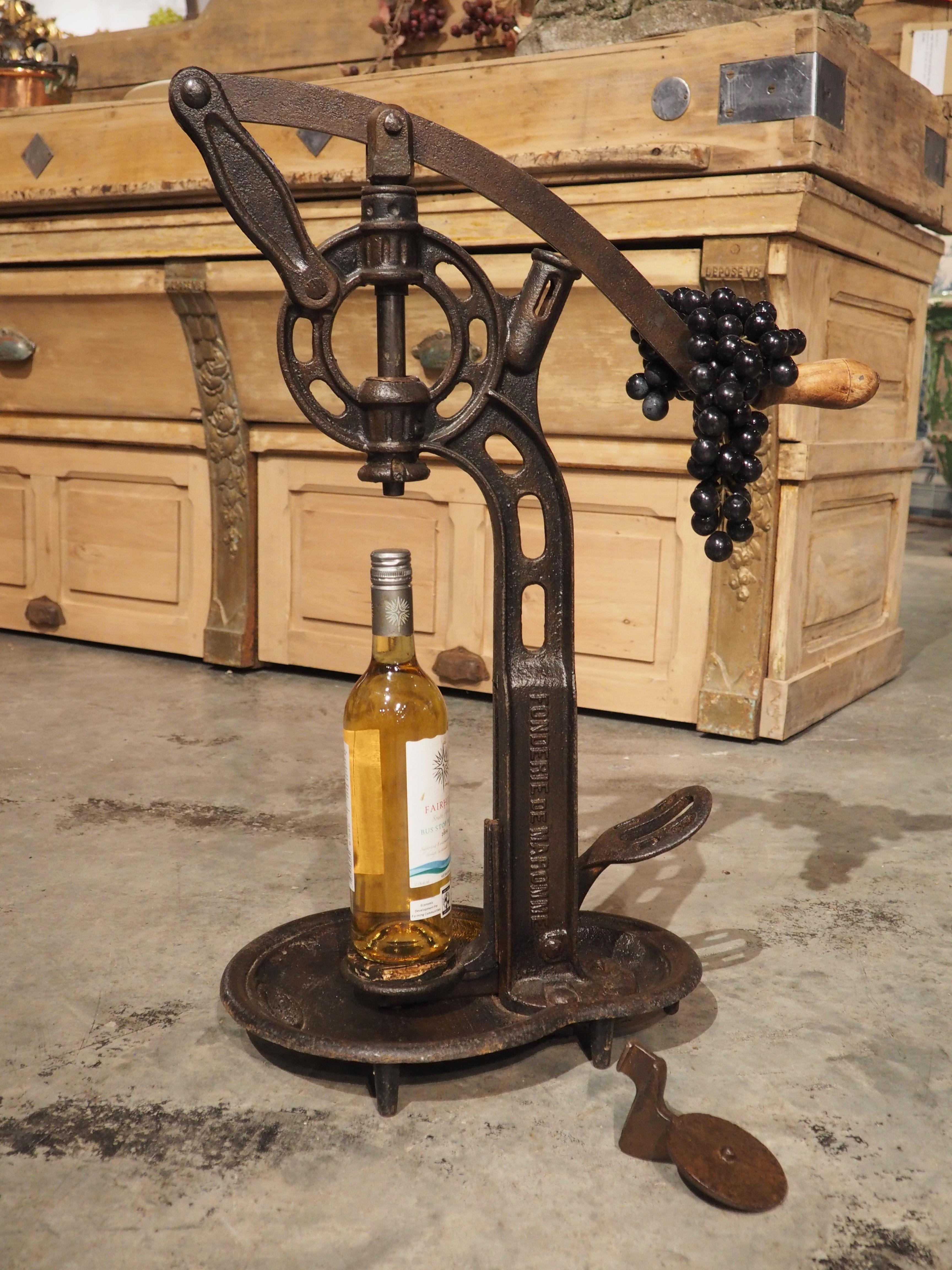 Known as a bouchonneuse, this French cast iron wine bottle corker would have been used at a vineyard in Normandy to seal wine bottles before the advent of mass production methods. Our model, which is from circa 1910, stands 26 3/4 inches tall and