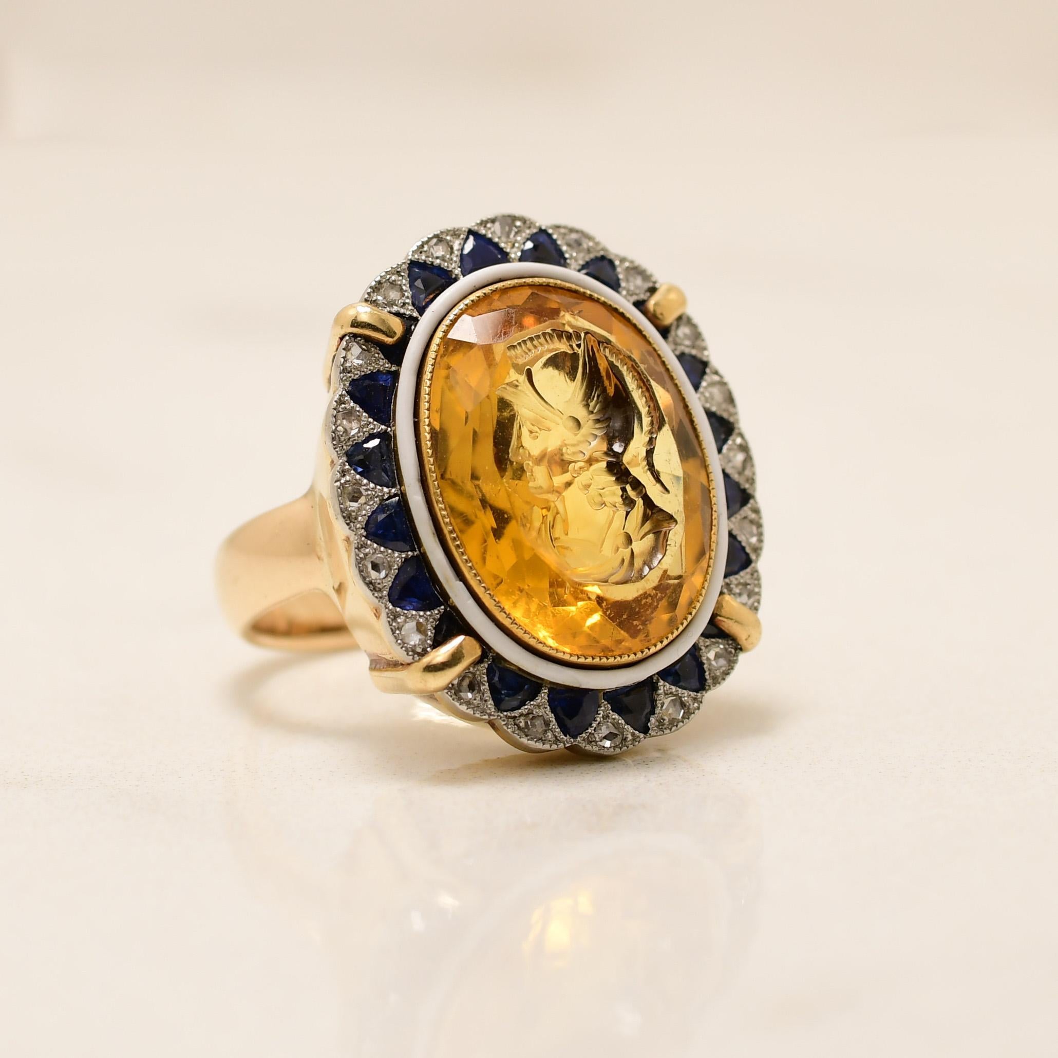 Here we have a uniquely bold treasure. Crafted in 14K yellow gold and platinum, the straight shanks hold a delicate scalloped edge halo. Uniquely done this halo is made up of single cut diamonds and rounded tris of deep blue sapphires. In the center