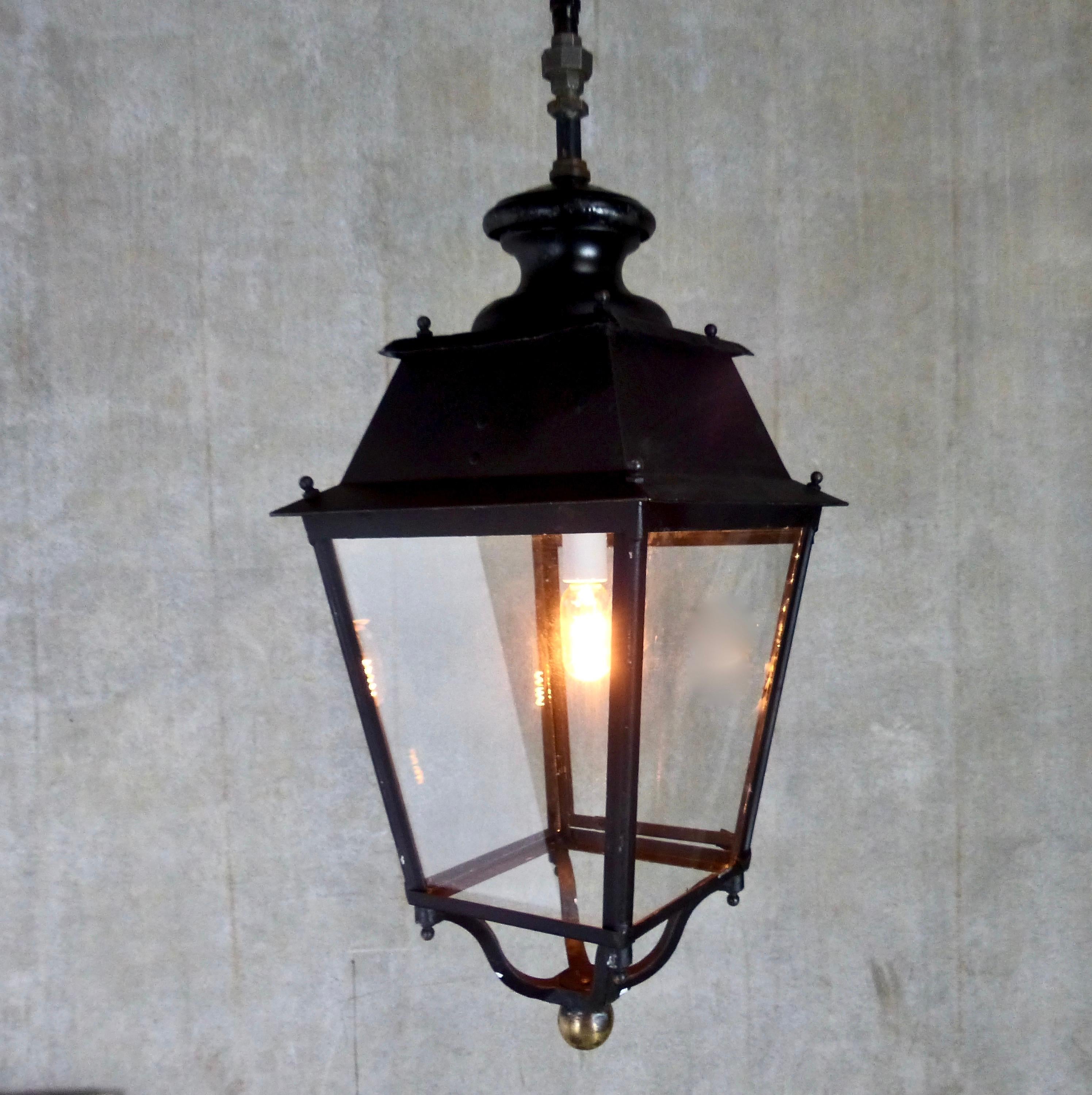 Sturdy cast iron lantern from circa 1920-1940. This pendant light is substantial, and features brass details. Four glass panels (one opens to replace bulbs) and a cast iron cap. Re-wired and inspected and approved to current electrical standards;