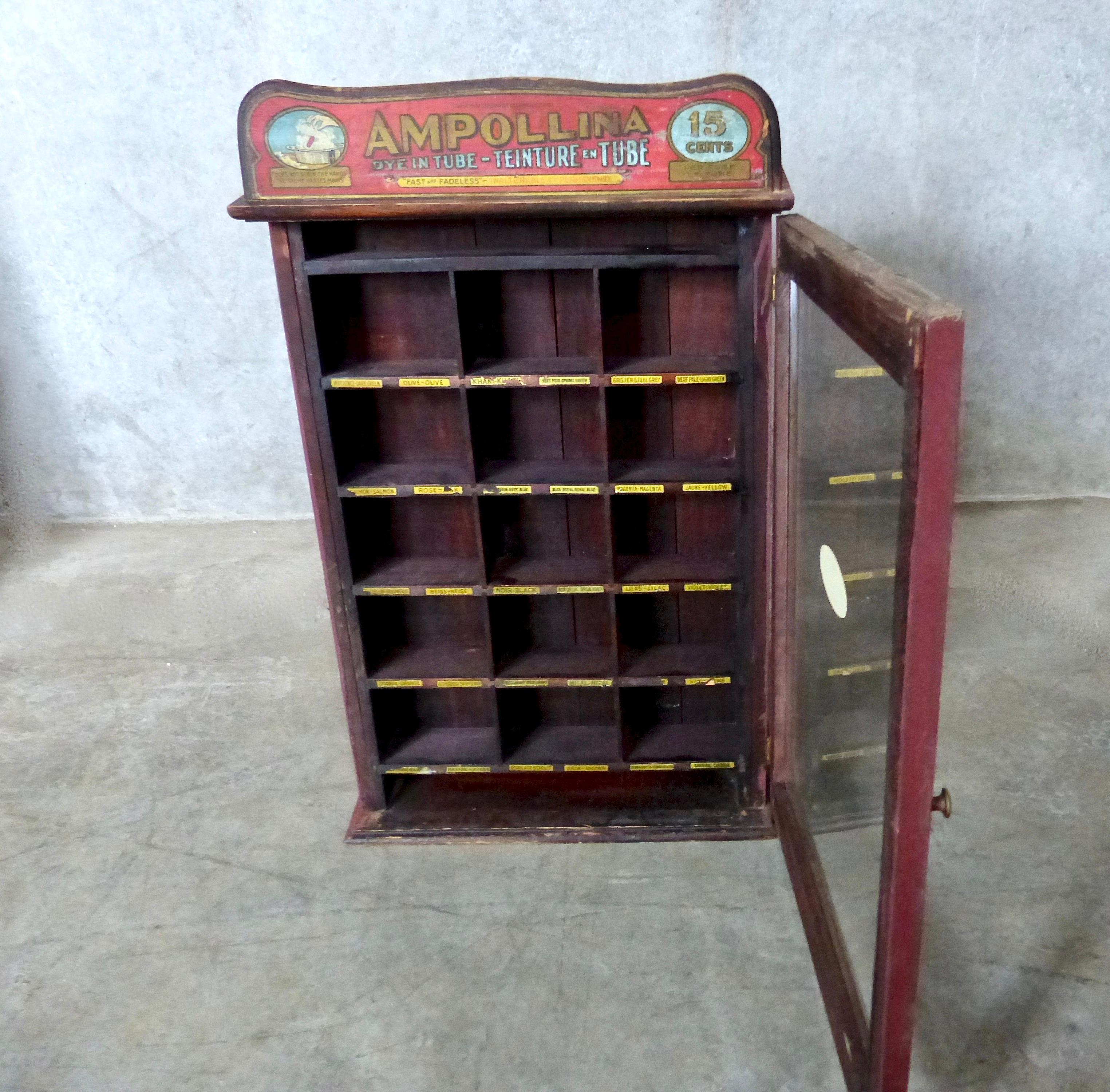 A small, apothecary-style wooden countertop cabinet used to merchandise Ampollina dyes from Germany. The nicely angled retail case from circa 1920 features a glass front panel plus a hidden area in the back to store additional stock. Labels and