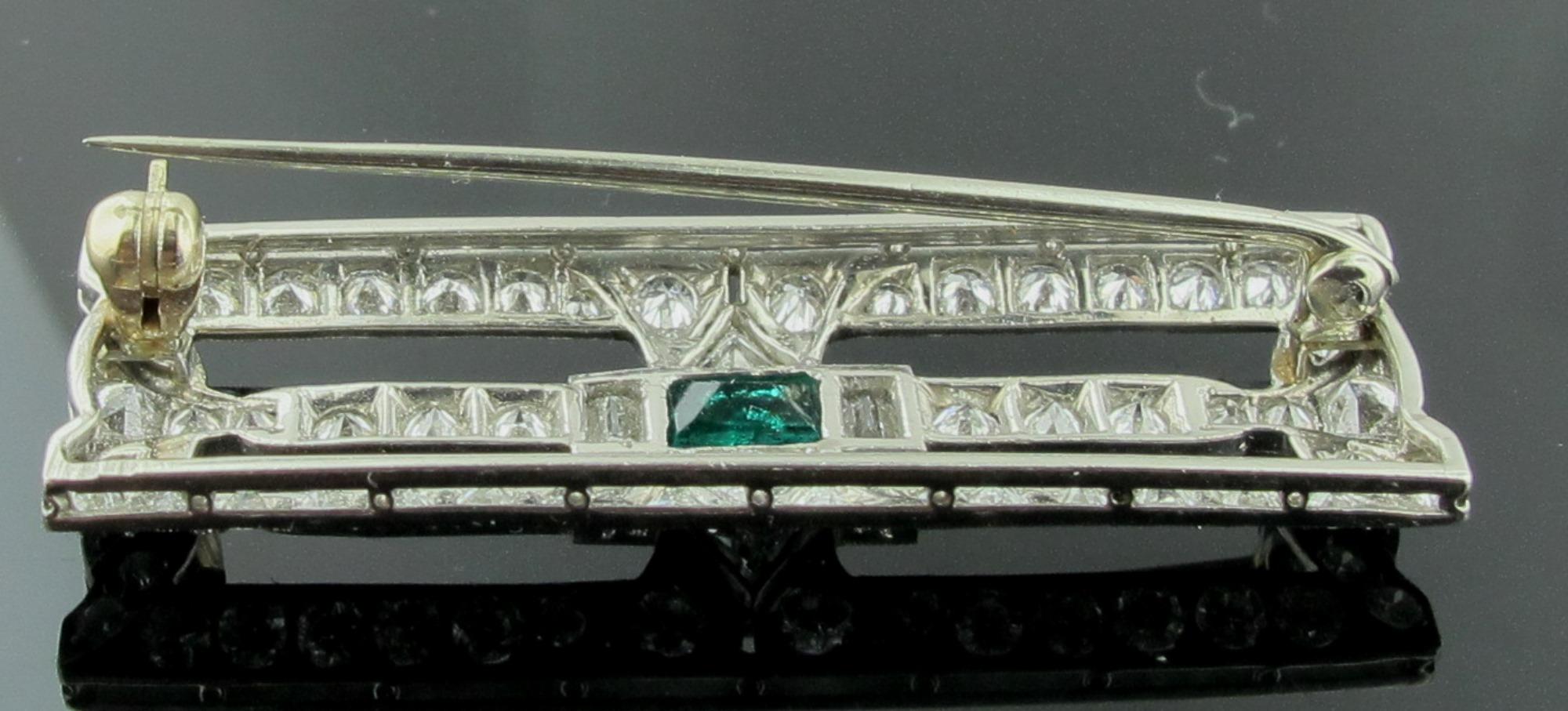 This square brooch is set in Platinum and has 49 round brilliant cut diamonds, 2 Trilliant cuts and 2 Baguette cuts for a total diamond weight of 4.25 carats.  In the center is an emerald cut Emerald.  This Brooch is Art Deco Circa 1920.